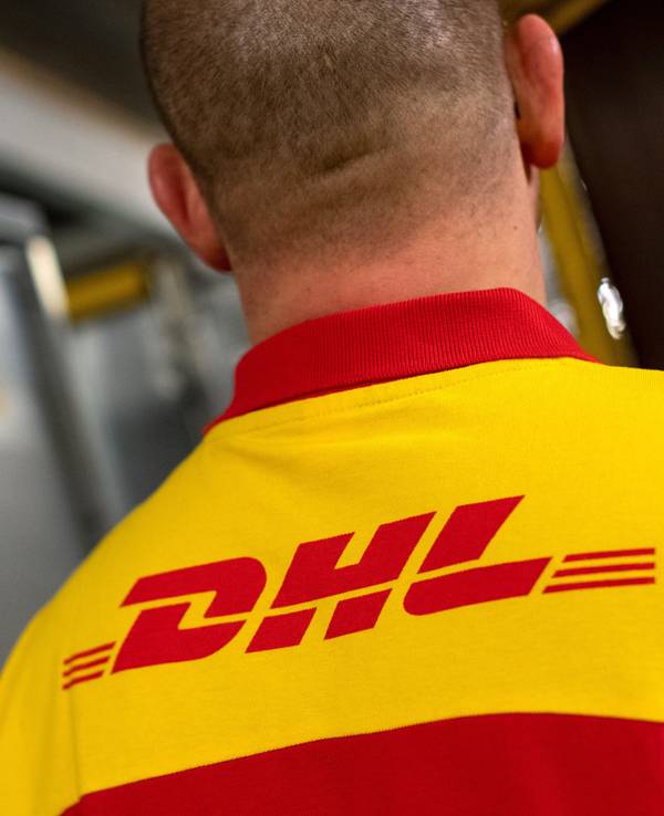 Ein DHL-Mitarbeiter steht im DHL-Paketzentrum.