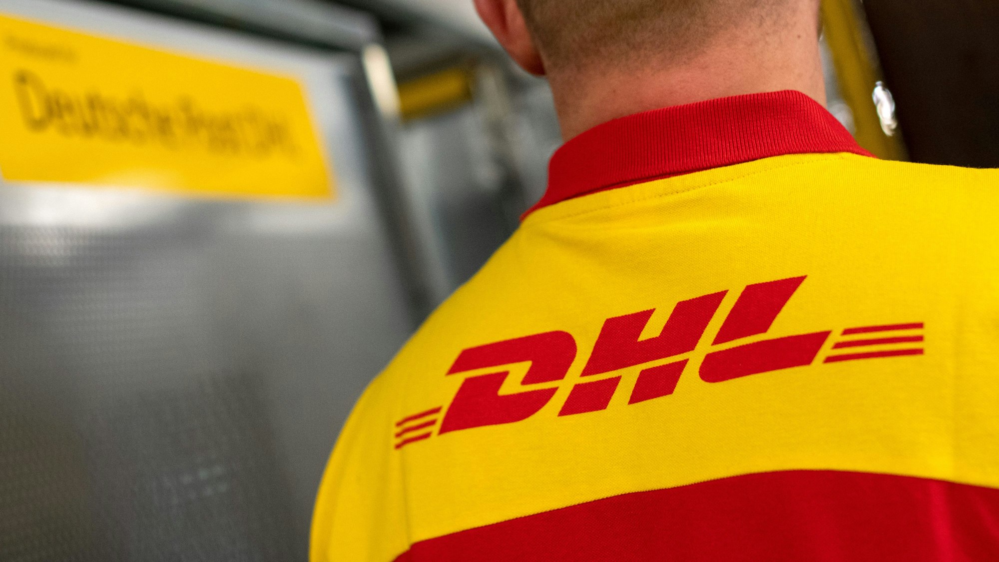 Ein DHL-Mitarbeiter steht im DHL-Paketzentrum.