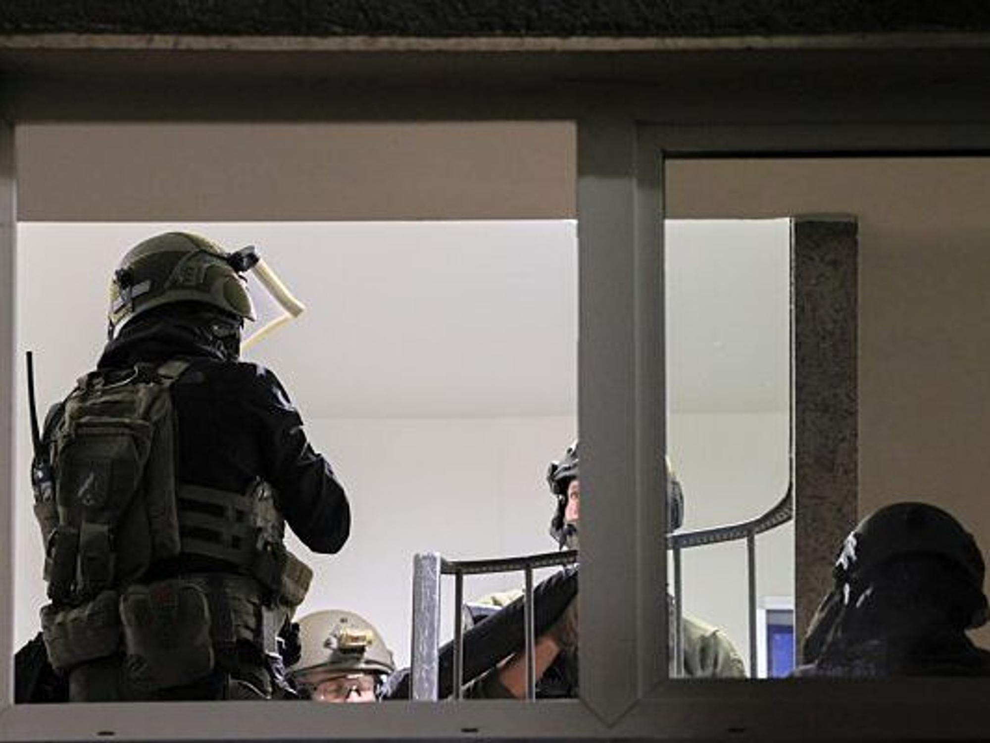 Spezialkräfte der Polizei stehen im Hausflur eines Mehrfamilienhauses. Ein sich selbst als Reichsbürger bezeichnender Mann hat in Velbert Polizisten mit einem Messer bedroht und damit einen SEK-Einsatz ausgelöst.
