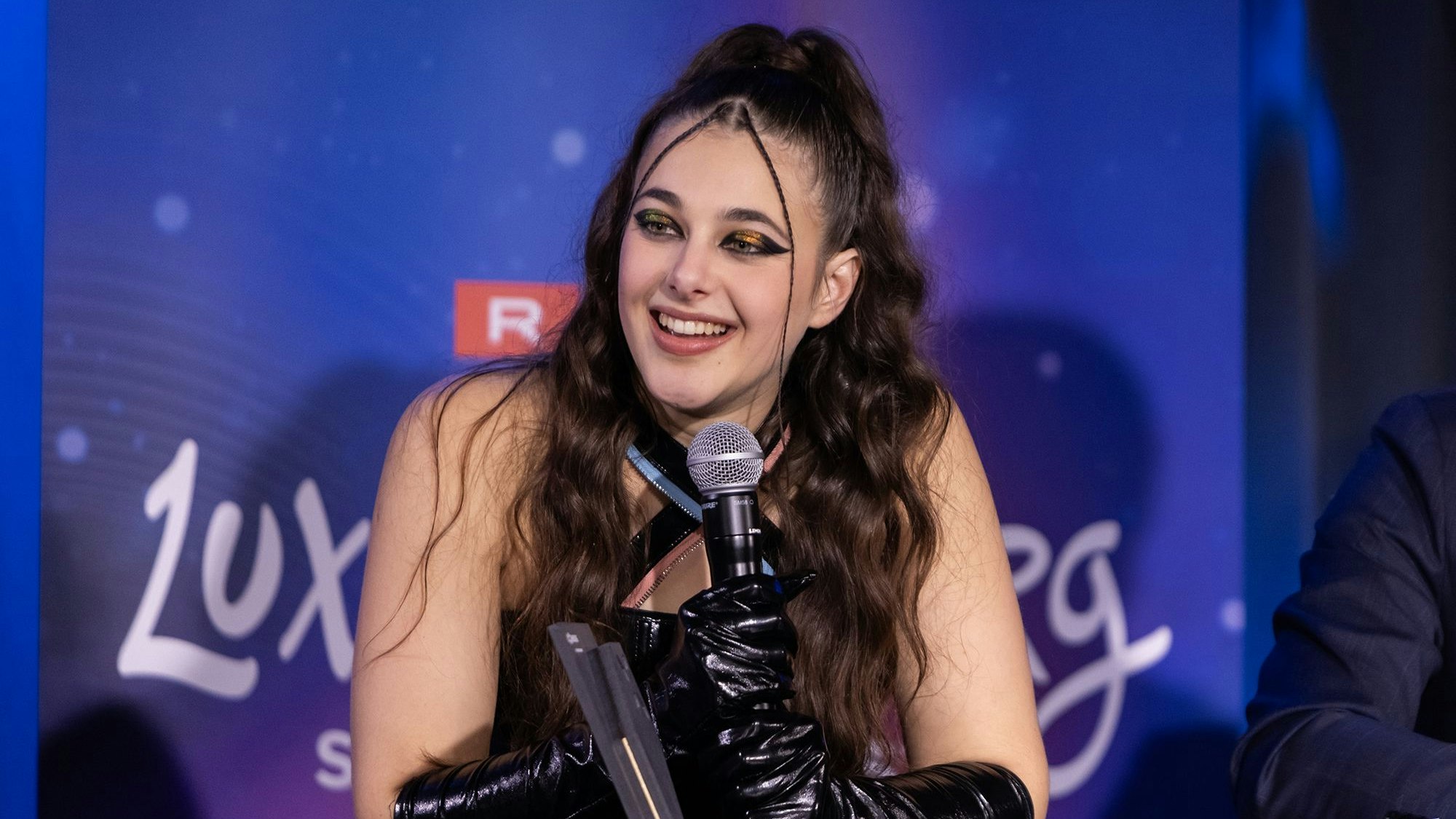 Tali spricht auf einer Pressekonferenz in ein Mikrofon.