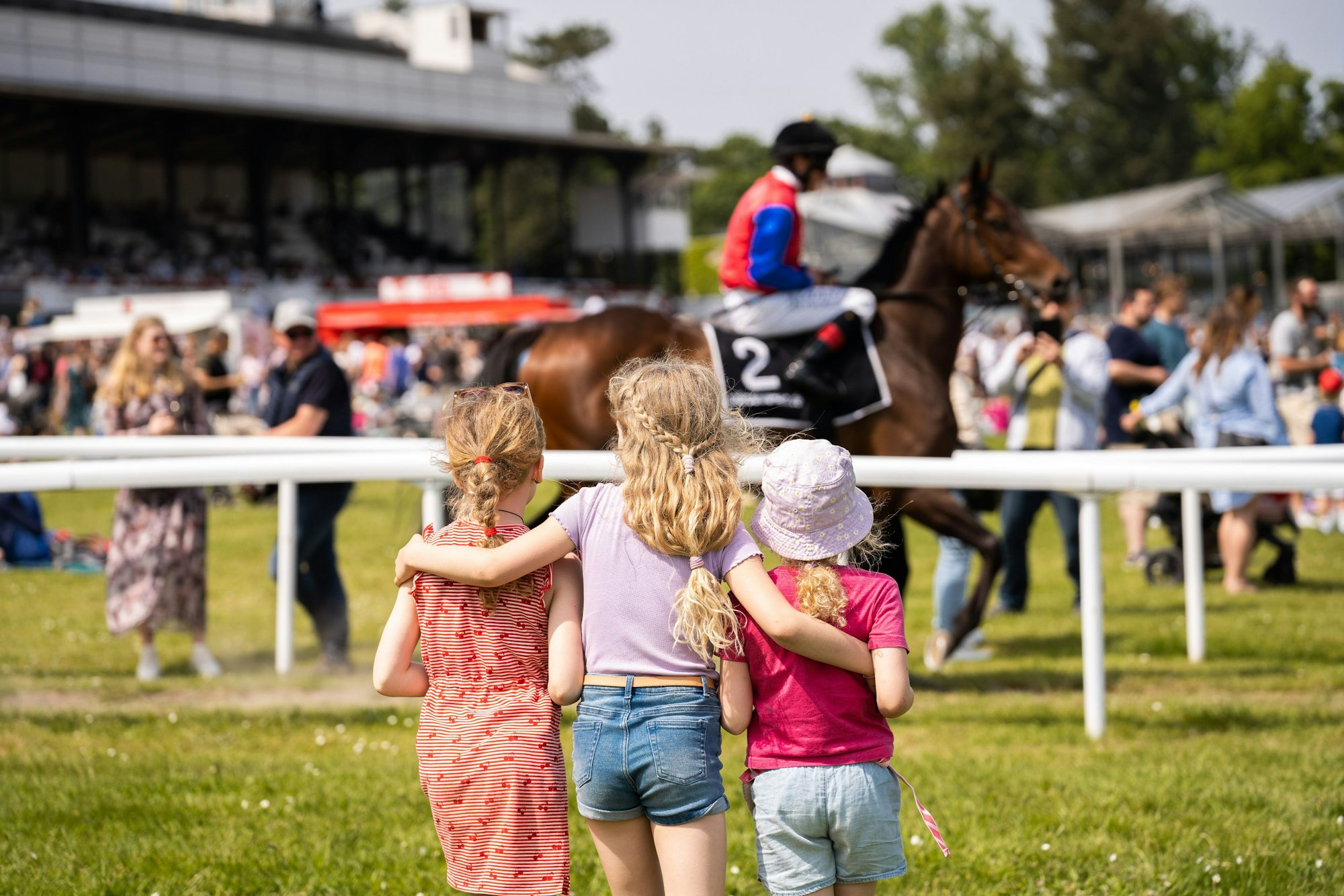 Drei Kinder stehen auf der Pferderennbahn in Weidenpesch