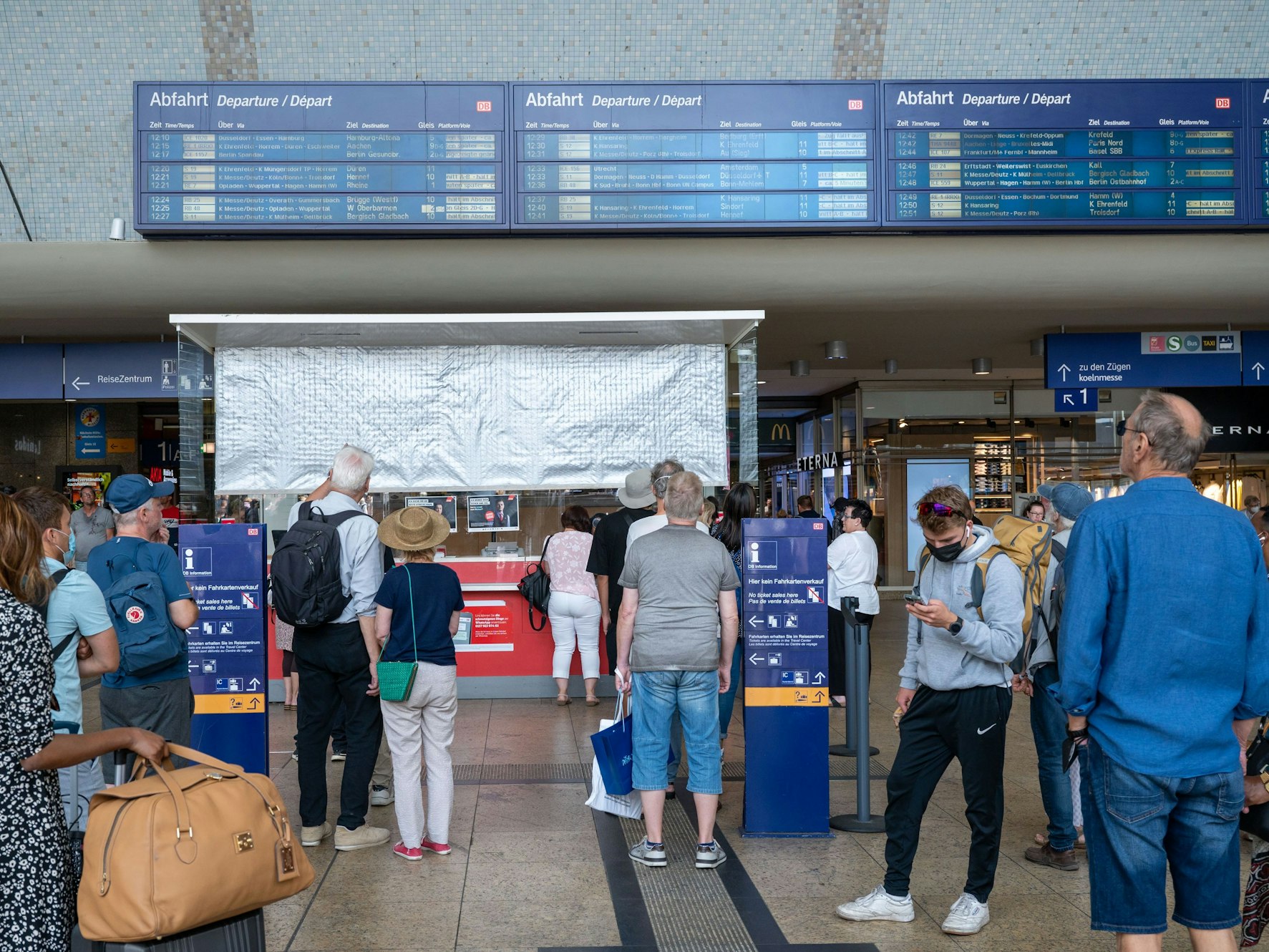 Reisende suchen nach Informationen auf den Anzeigetafeln im Hauptbahnhof.