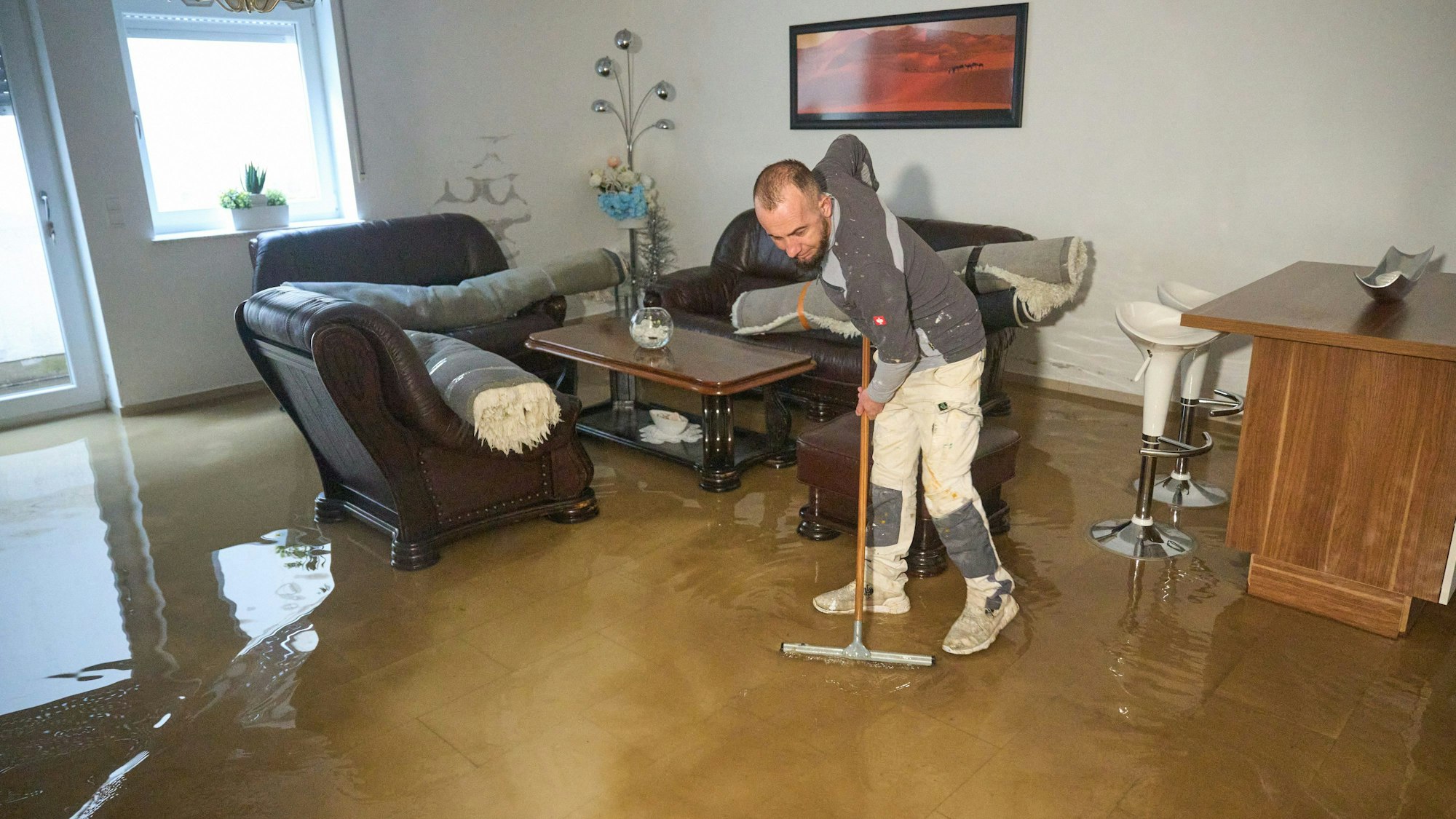 Nach unwetterartigen Regenfällen in Bad Neuenahr reinigt ein Helfer am 2. Mai eine Kellerwohnung.