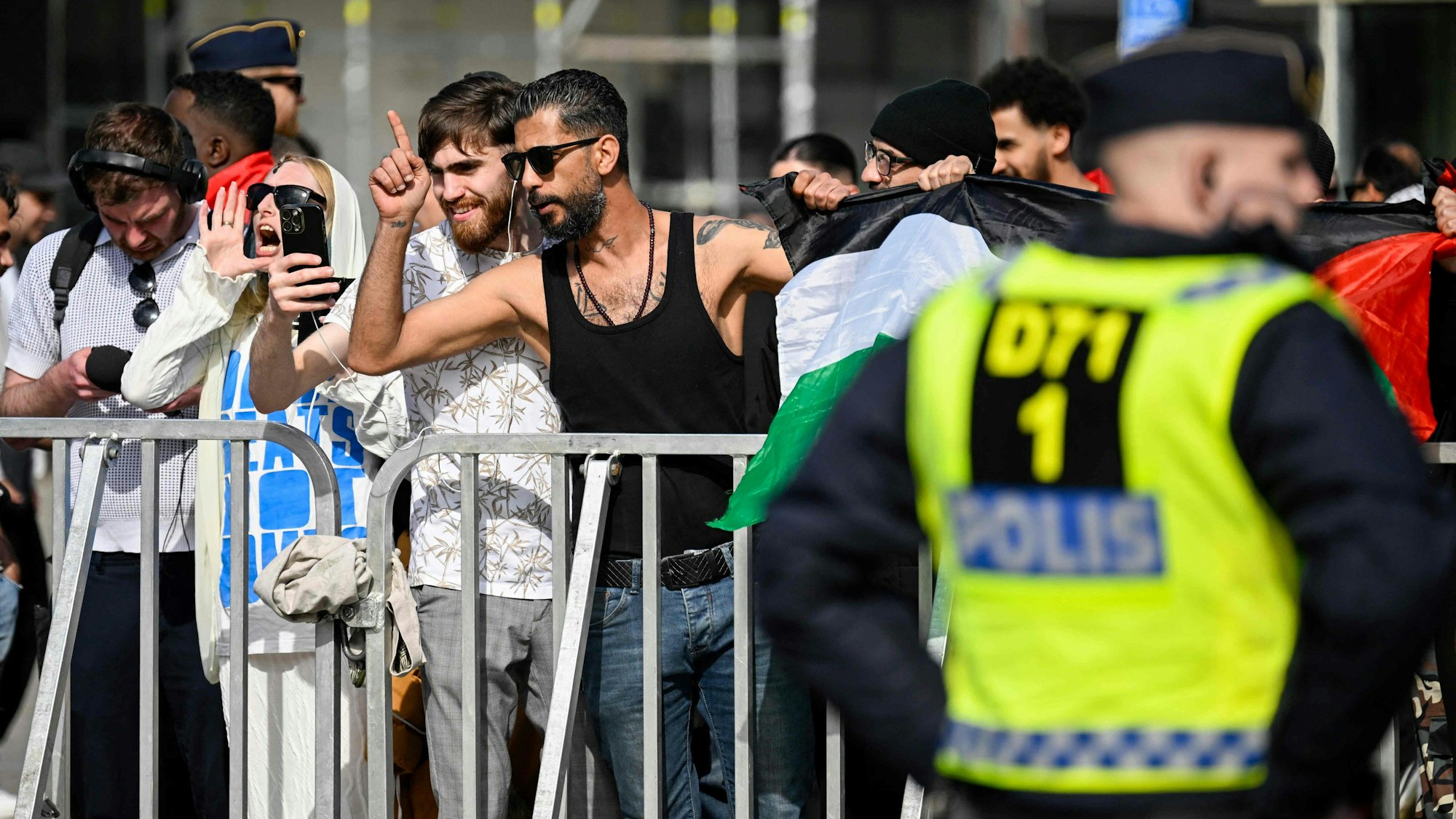 Gegendemonstrantinnen und -demonstranten sowie Polizeikräfte sind am 3. Mai 2024 auf dem Gustav-Adolfs-Torg-Platz in Malmö zu sehen. Anlass ist eine öffentliche Versammlung, bei der ein Tag vor Beginn des ESC ein Koran verbrannt werden soll.