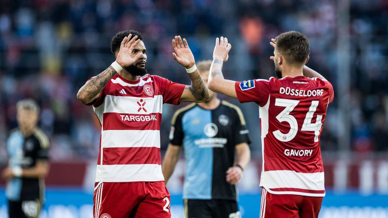 Die Düsseldorfer Spieler Jamil Siebert und Nicolas Gavory klatschen sich im Spiel gegen den 1. FC Nürnberg ab.