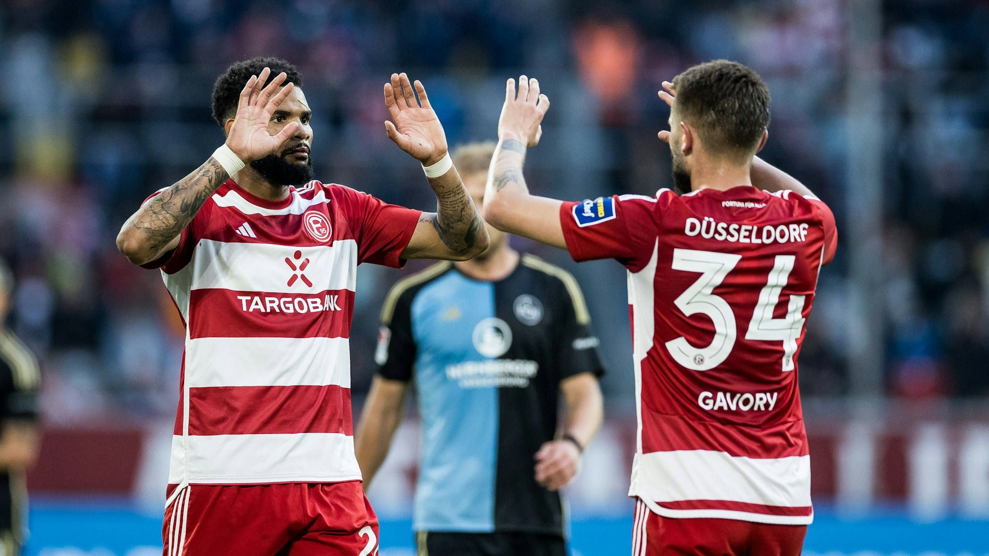 Die Düsseldorfer Spieler Jamil Siebert und Nicolas Gavory klatschen sich im Spiel gegen den 1. FC Nürnberg ab.