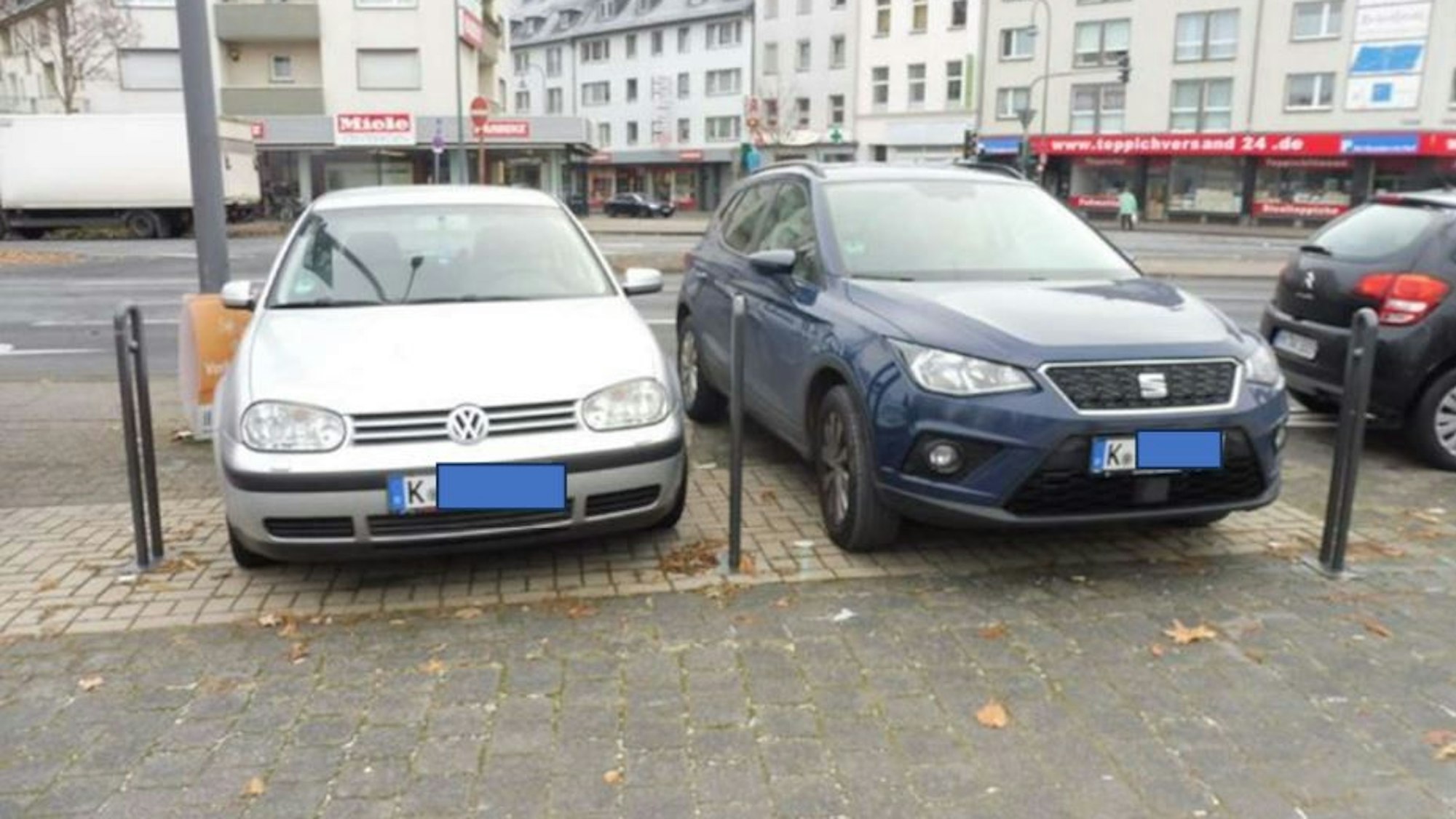 Hier parken zwei Autos im Bereich von Fahrradstellplätzen.