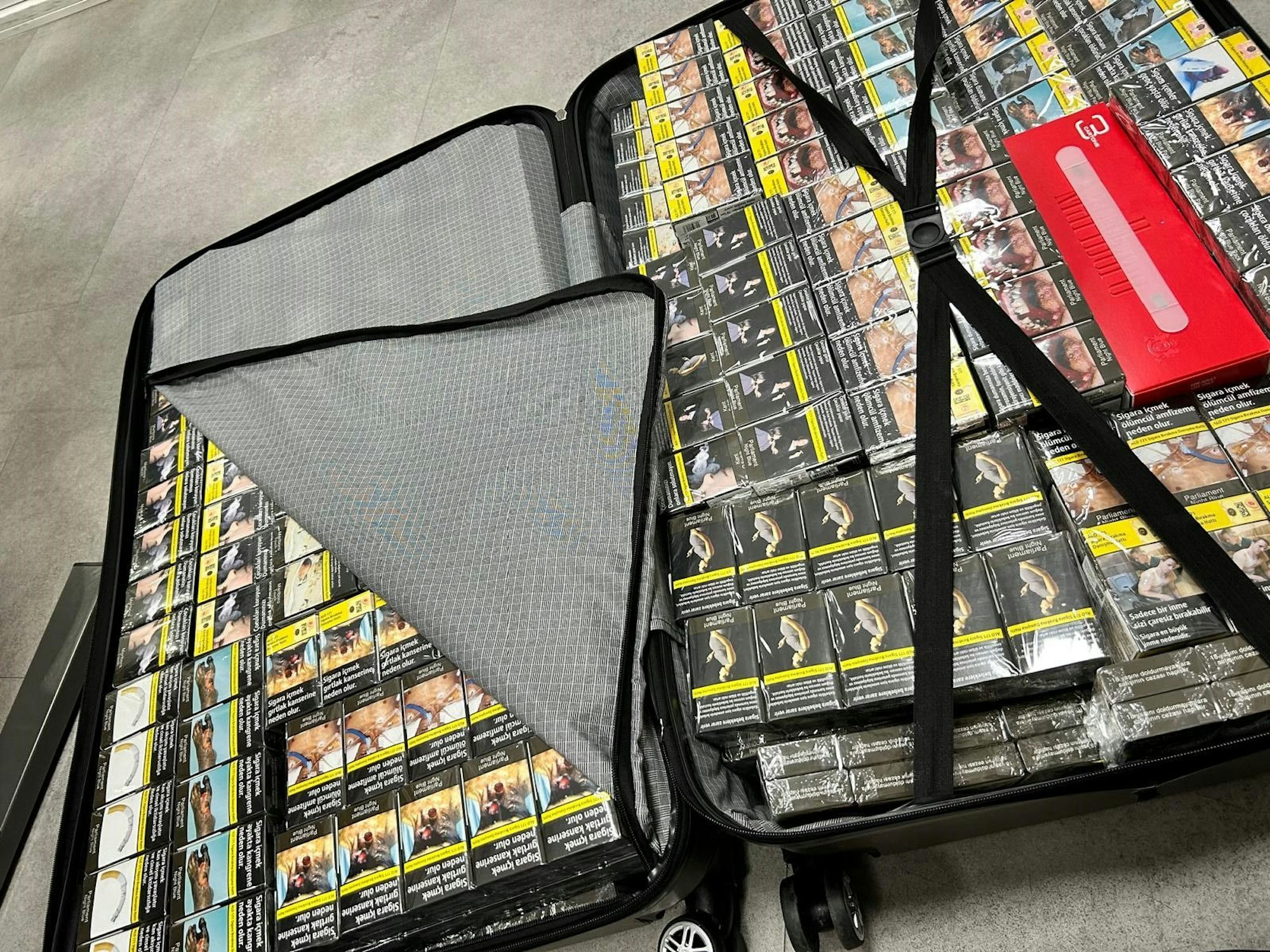 Ein Koffer ist vollgepackt mit Zigarettenschachteln.
