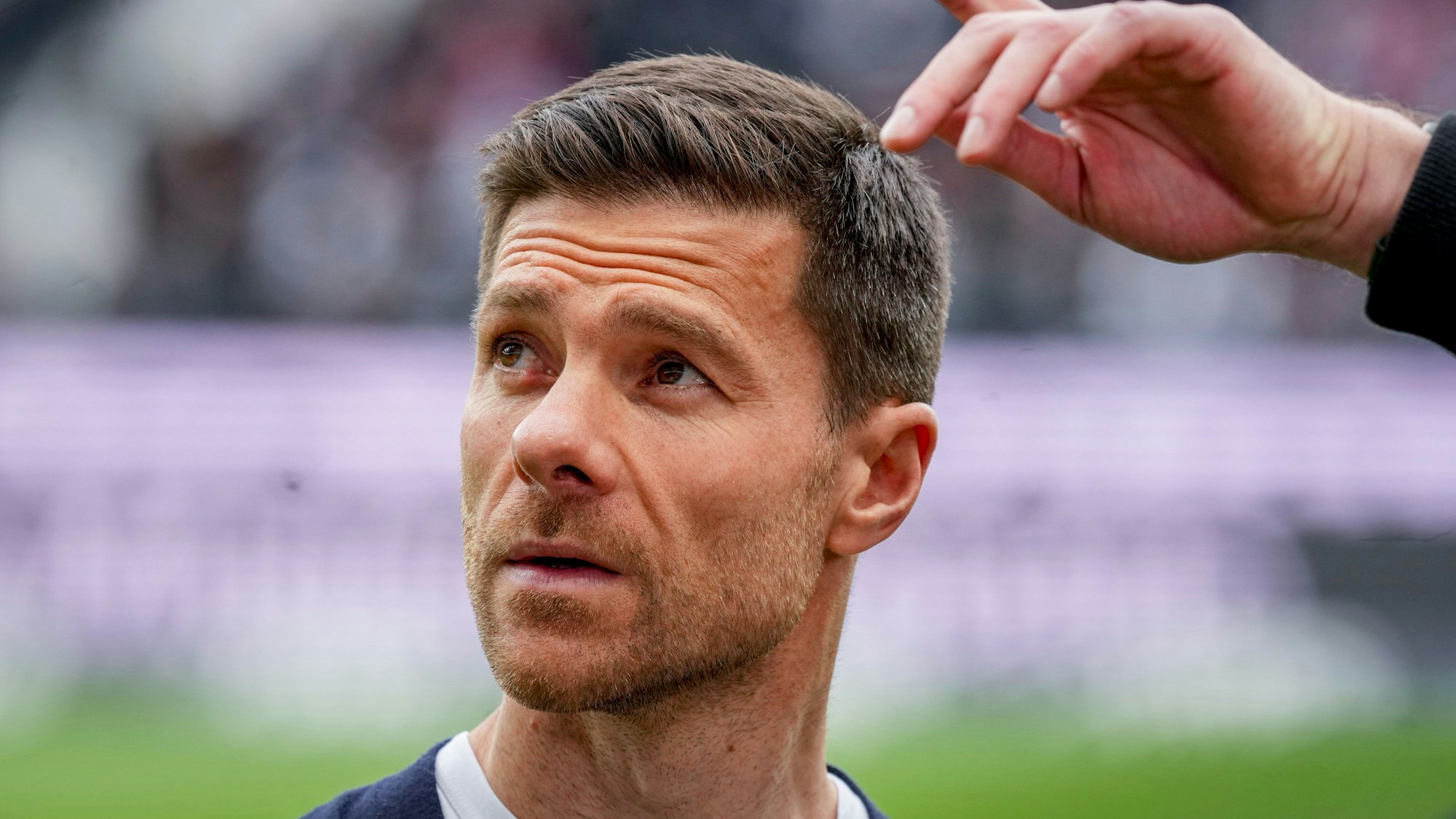 Xabi Alonso blickt im Stadion vor einem Spiel von Bayer Leverkusen nach oben.