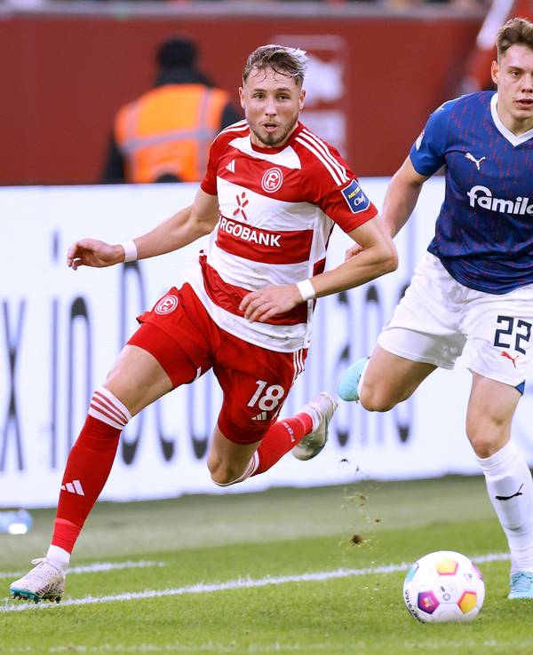 Fortuna Düsseldorfs Jona Niemiec und Kiels Nicolai Remberg blicken dem Ball hinterher.