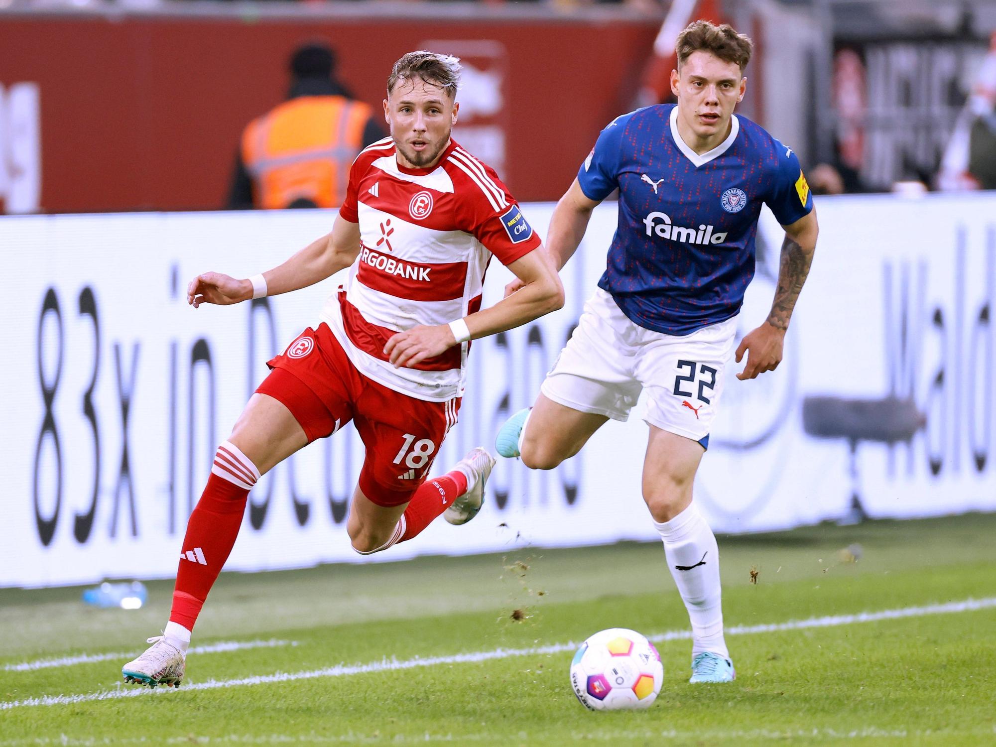 Fortuna Düsseldorfs Jona Niemiec und Kiels Nicolai Remberg blicken dem Ball hinterher.