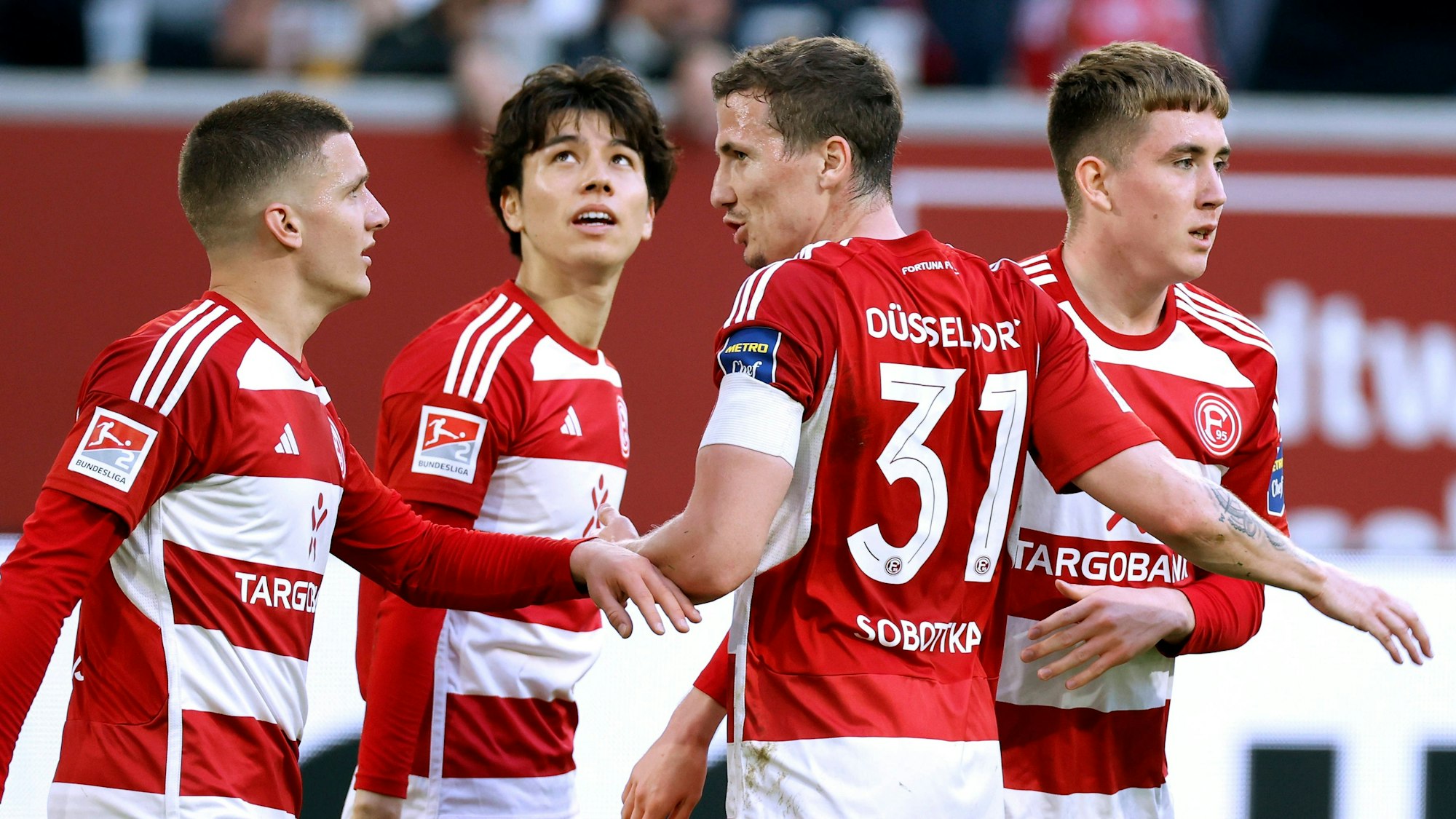 Die Düsseldorf-Profis Christos Tzolis, Ao Tanaka, Marcel Sobottka und Isak Johannesson jubeln gemeinsam im Spiel gegen den 1. FC Nürnberg.