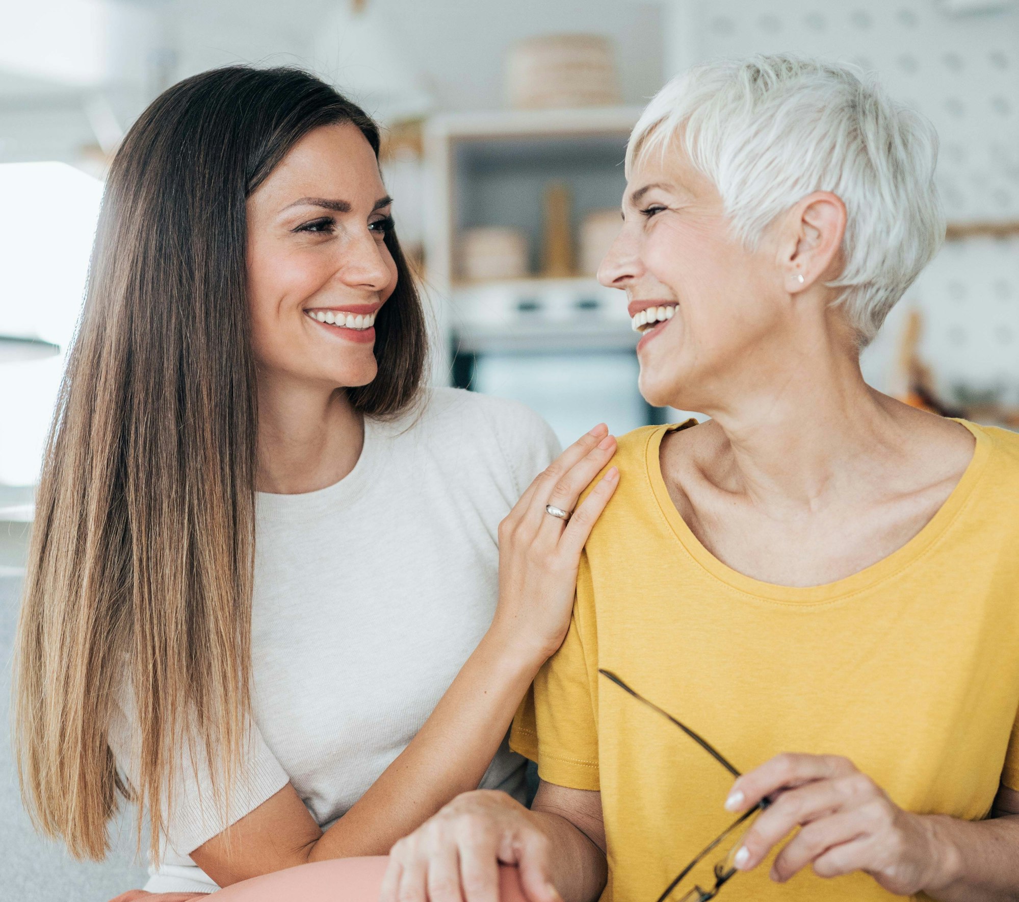 Junge und ältere Frau lächeln sich an.