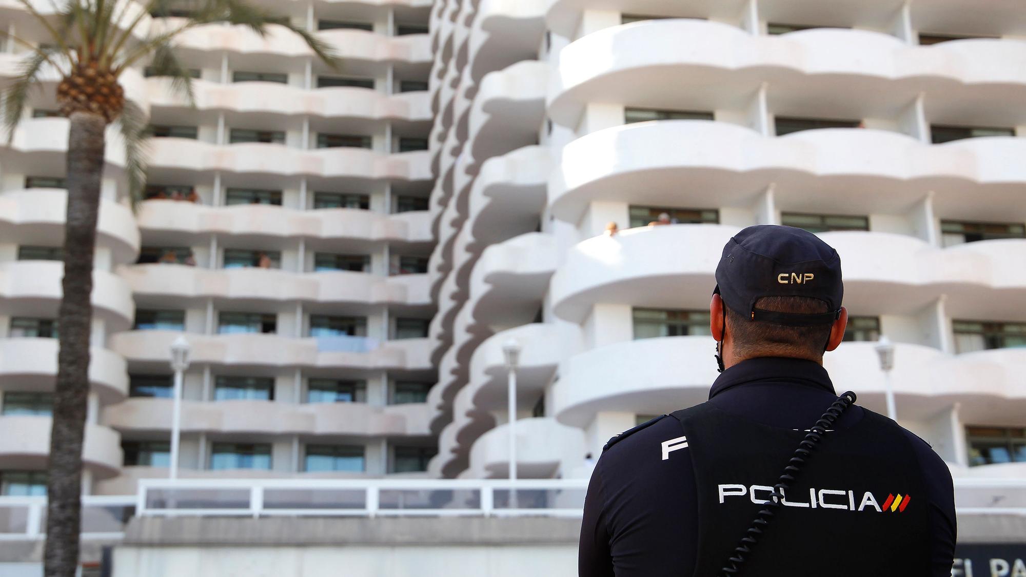 Ein Polizist steht vor einem Hotel.
