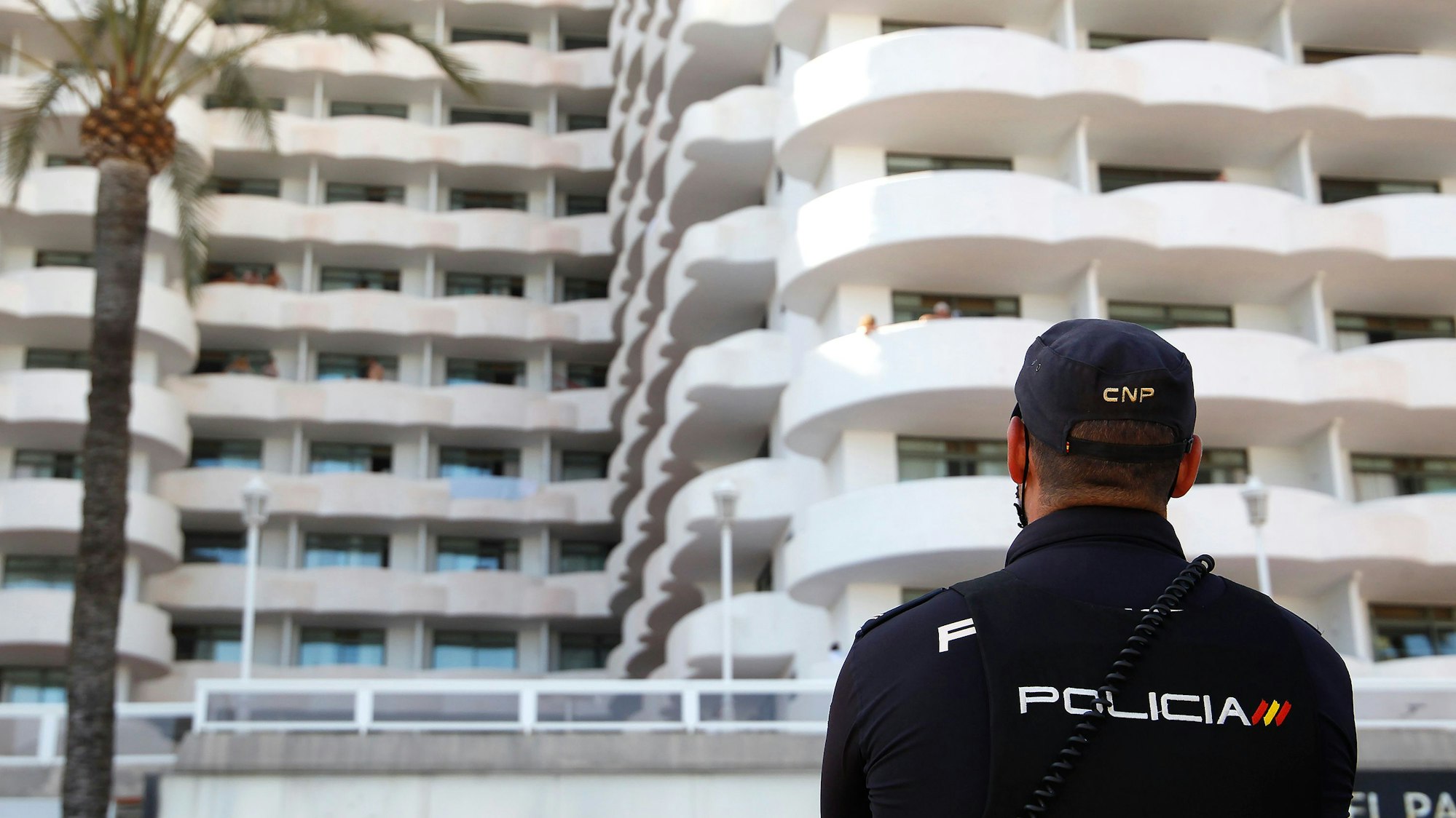 Ein Polizist steht vor einem Hotel.