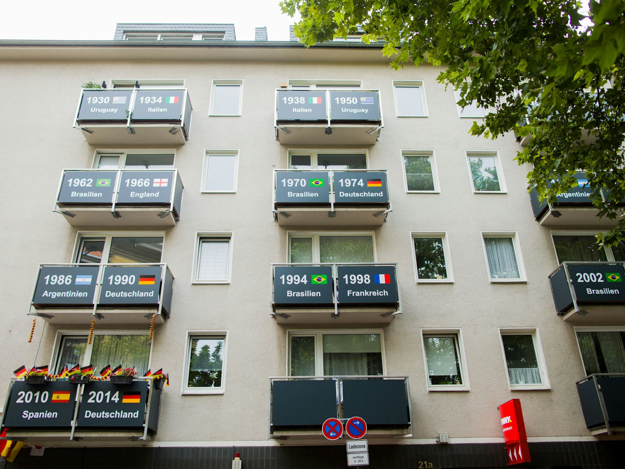 Blick auf die Fassade eines Hauses in Köln, auf denen die Weltmeister der bisherigen Fußball-WMs auf den Balkonen gezeigt werden.