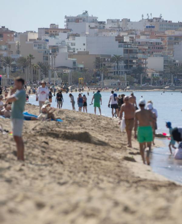 Menschen spazieren am Strand.