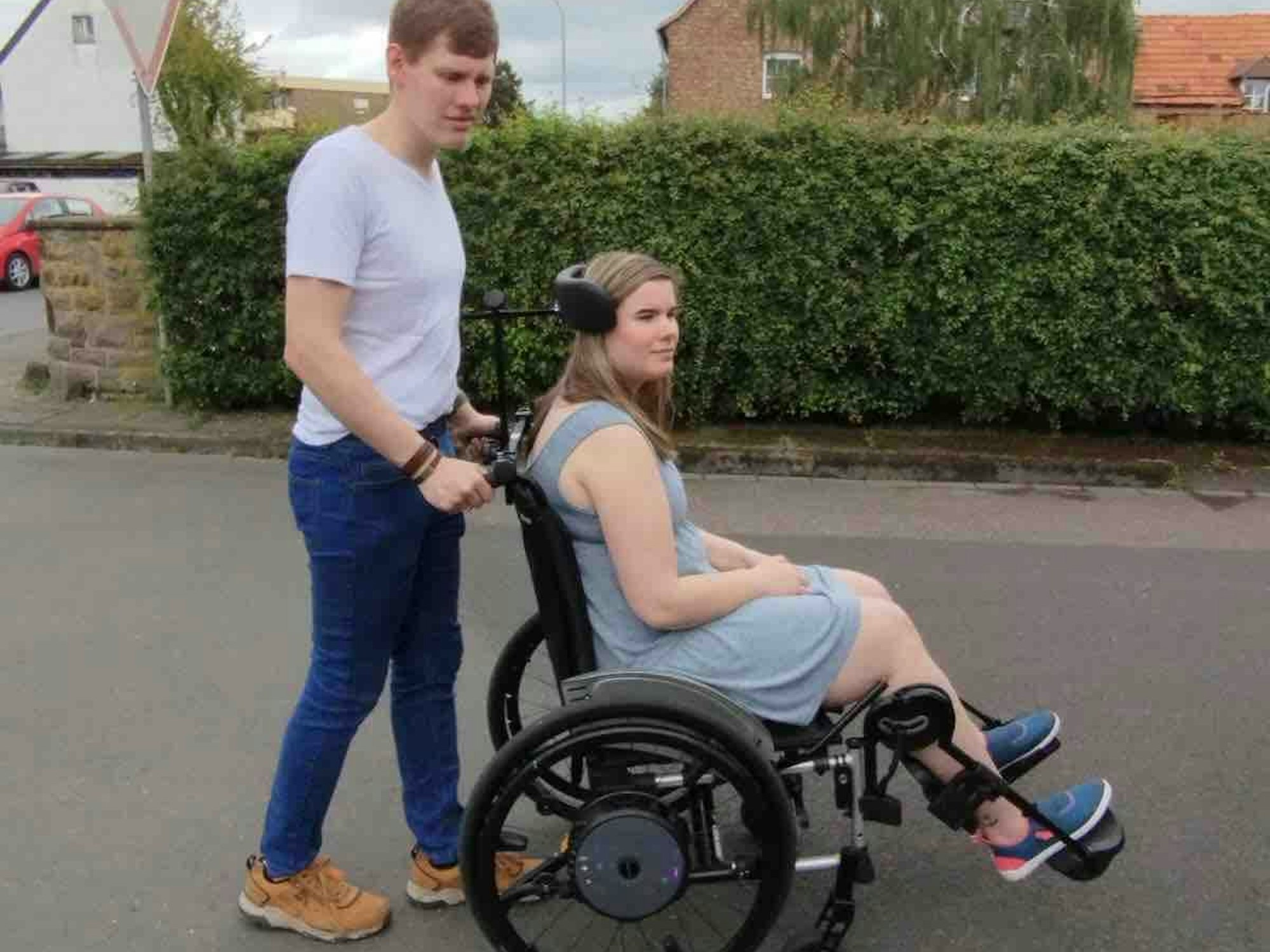 Daniel schiebt seine erkrankte Frau in einem Rollstuhl.