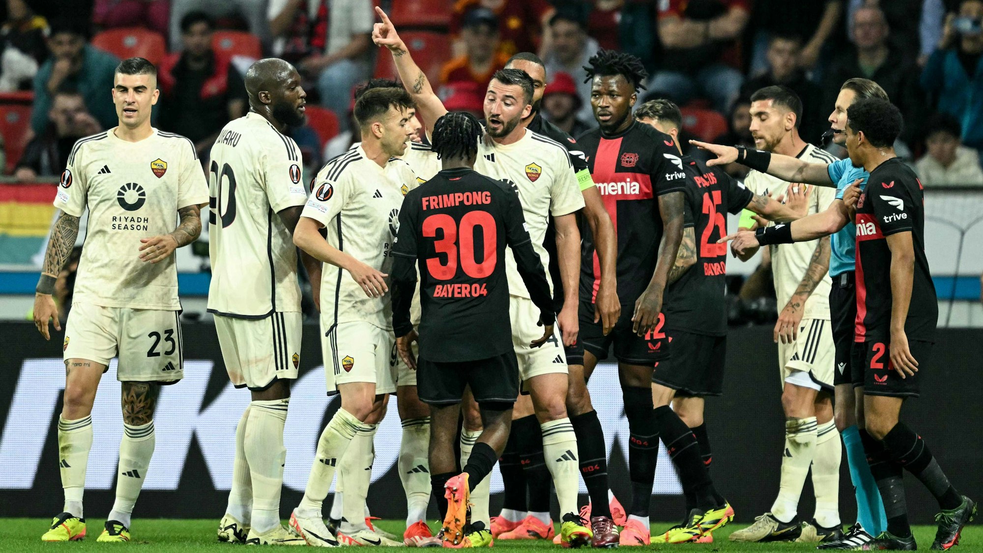 Spieler von Bayer Leverkusen und der AS Rom sind am Diskutieren.
