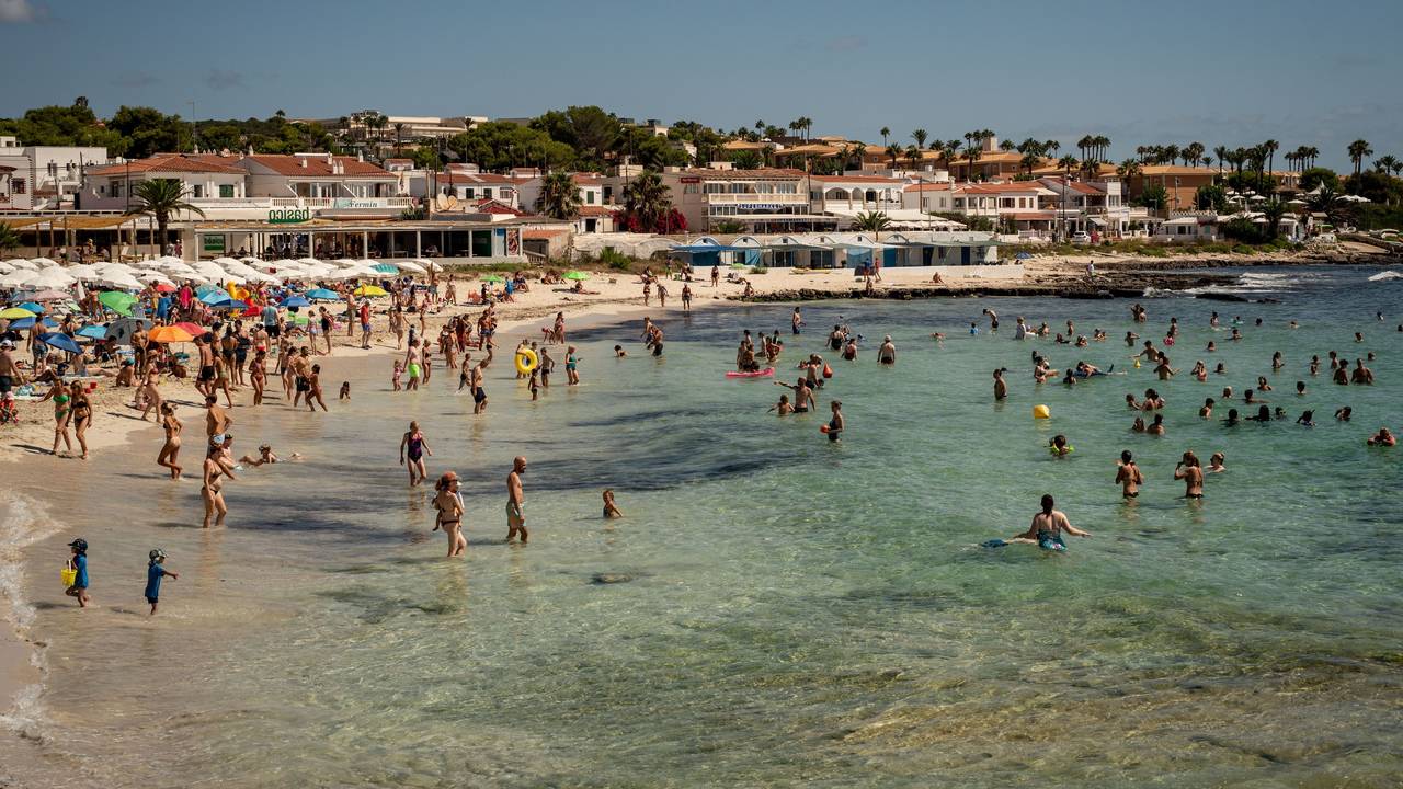 Urlauberinnen und Urlauber kühlen sich am Strand Punta Prima in Sant Lluis im Süden Menorcas im Wasser ab. Das Foto wurde im Sommer 2023 aufgenommen.