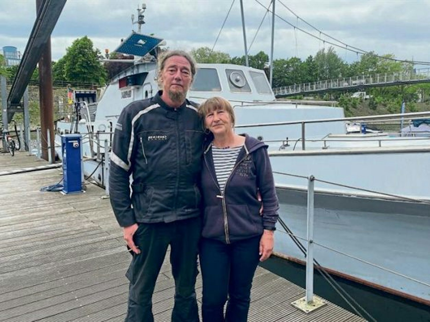 Birgit und Sascha stehen im Hafen von Duisburg vor ihrem Schiff.