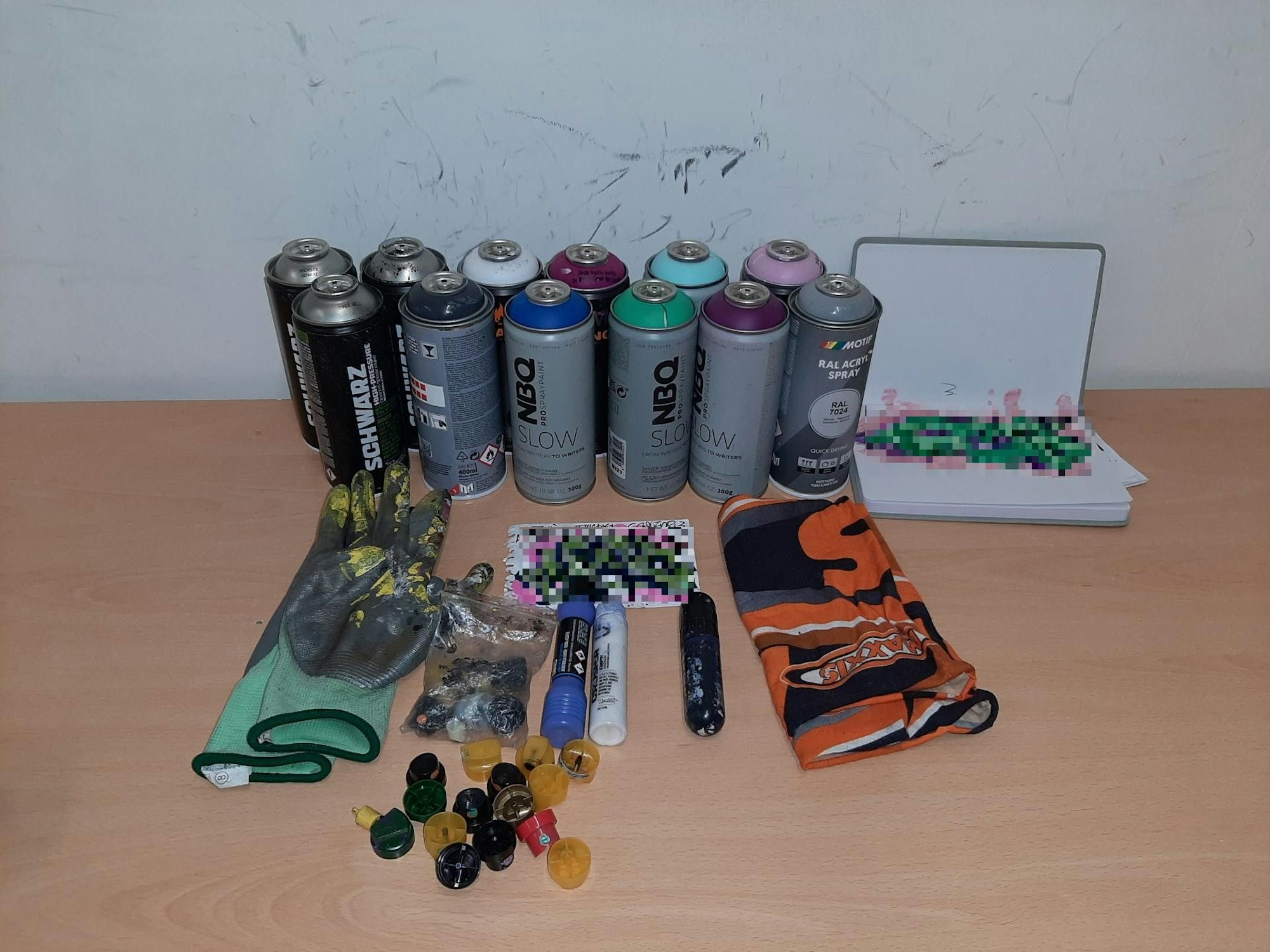 Spraydosen und Aufsätze liegen auf einem Tisch.