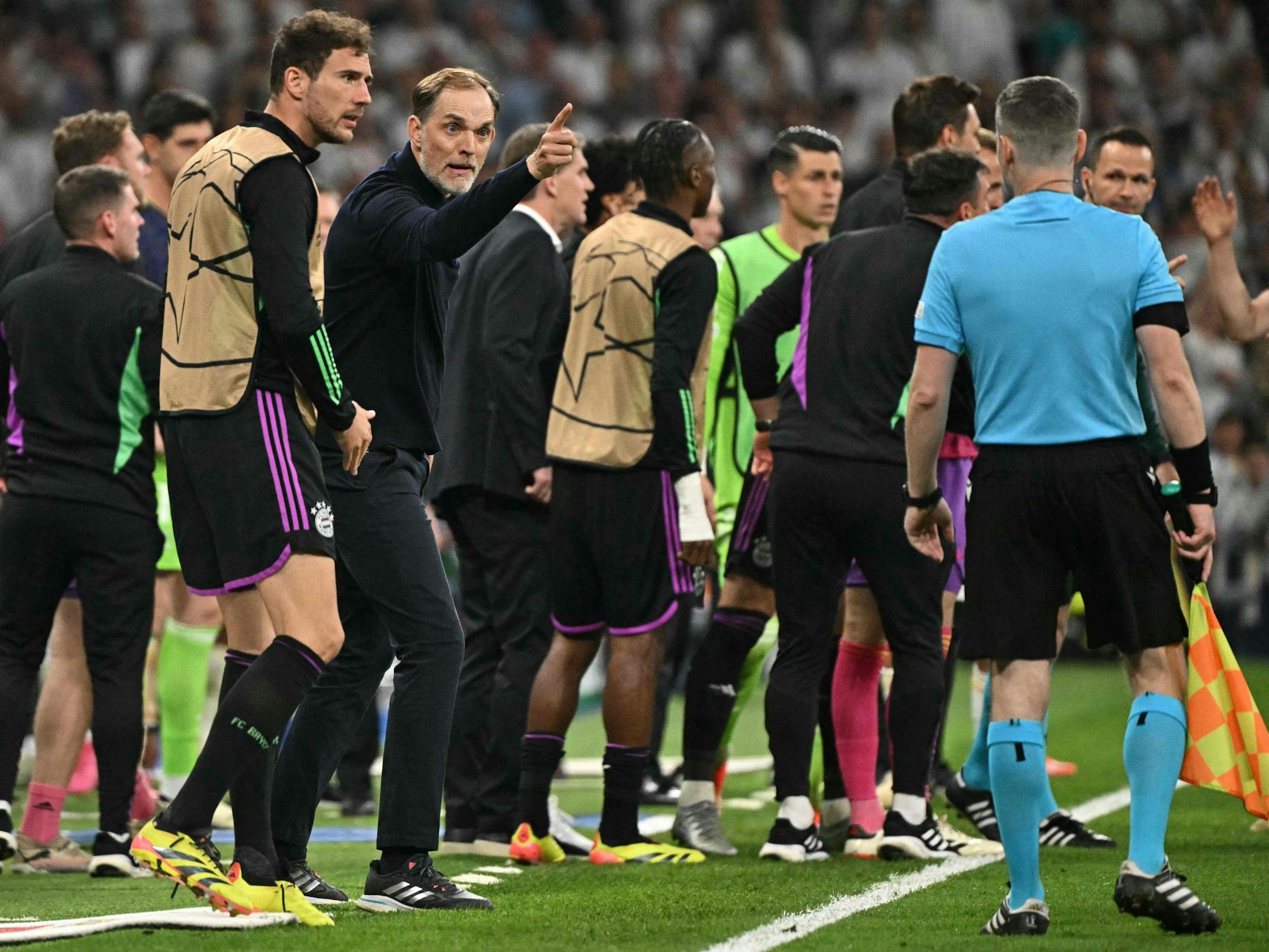 Bayern-Coach Thomas Tuchel (2.v.l.) zeigt mit erhobenen Finger zum Linienrichter.