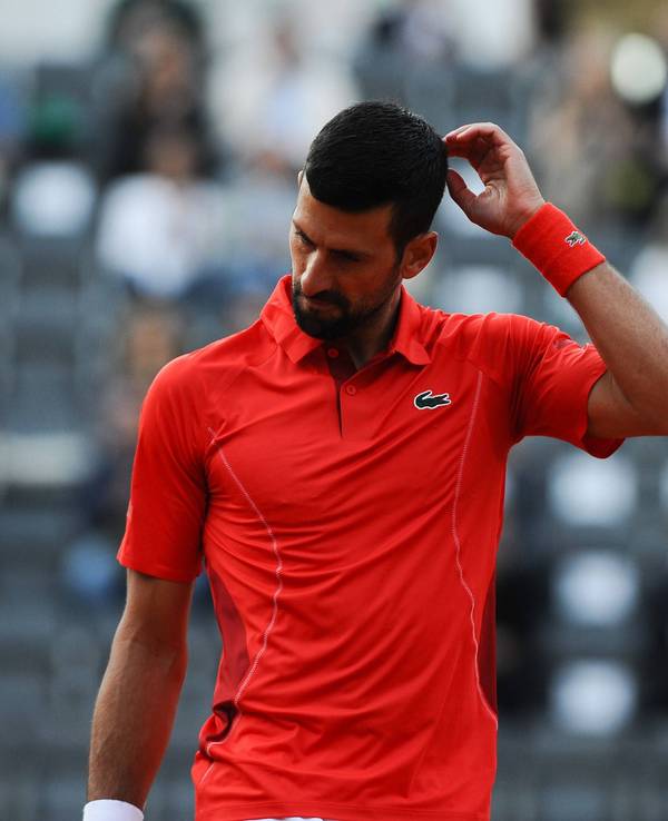 Novak Djokovic kratzt sich auf dem Tennisplatz am Kopf.