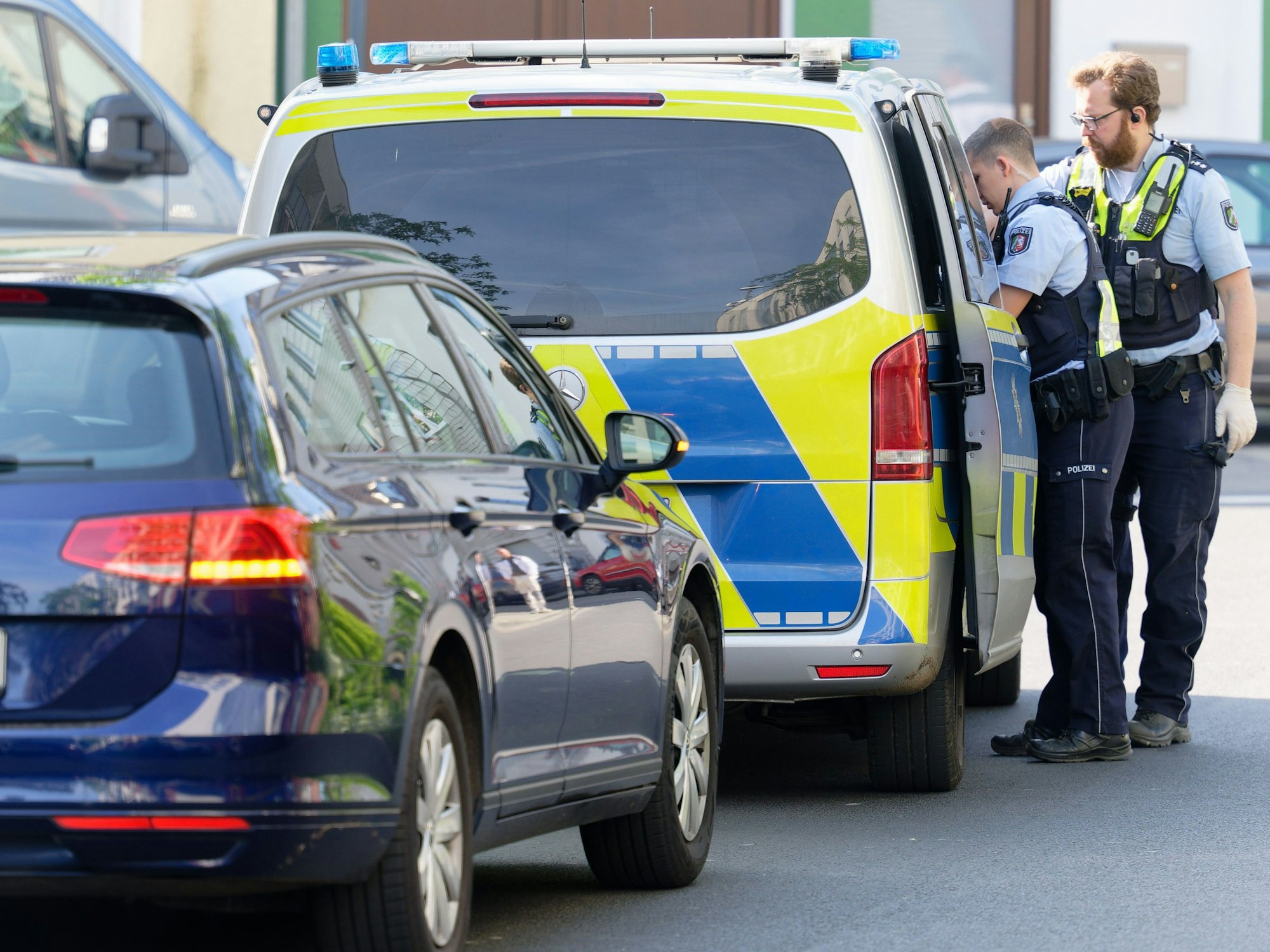 Ein Polizeiauto steht in einer Straße am Rand des Bürgerparks in Köln-Kalk.