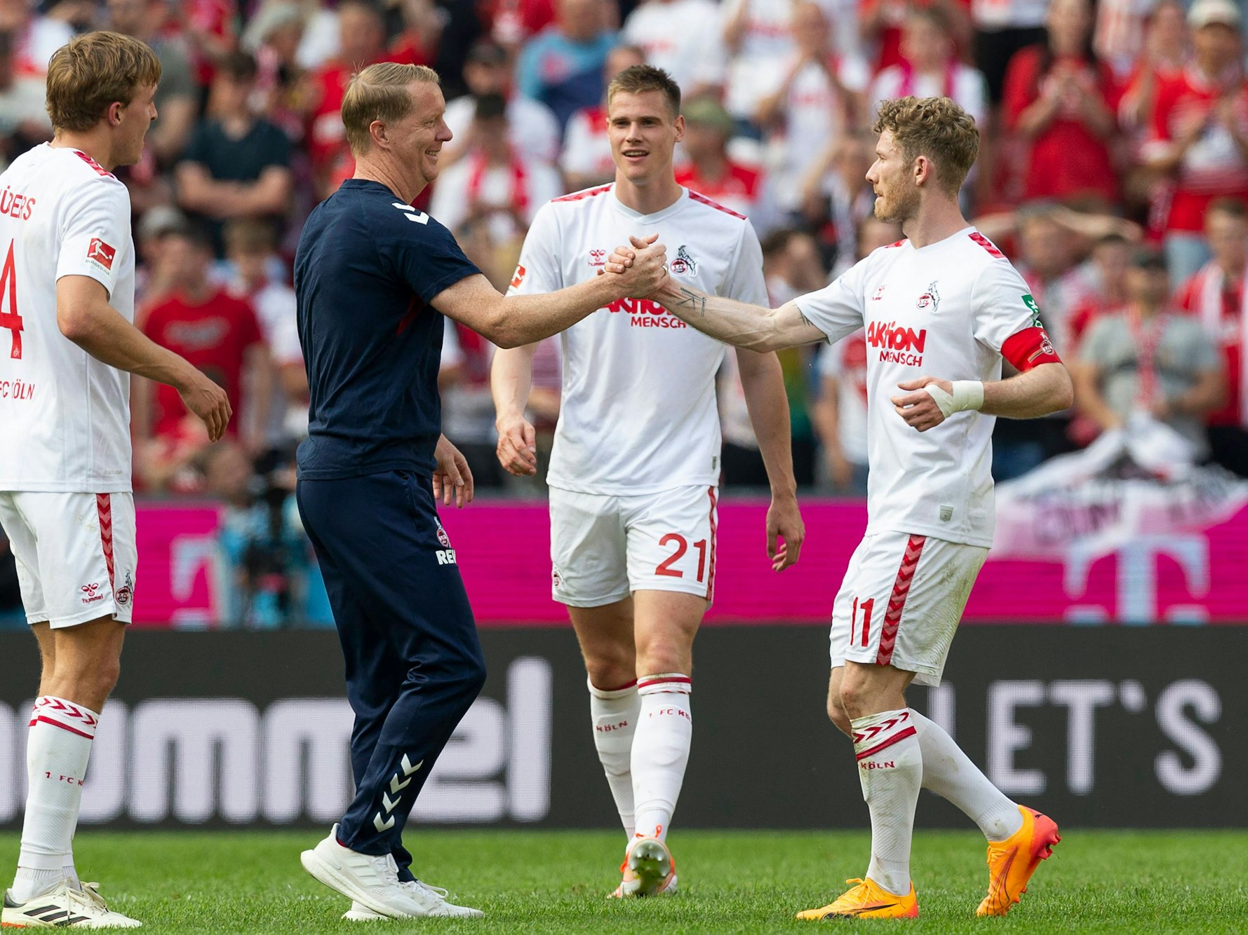 Timo Schultz und Florian Kainz klatschen sich nach dem FC-Sieg am Samstag (11. Mai 2024) gegen Union Berlin ab.