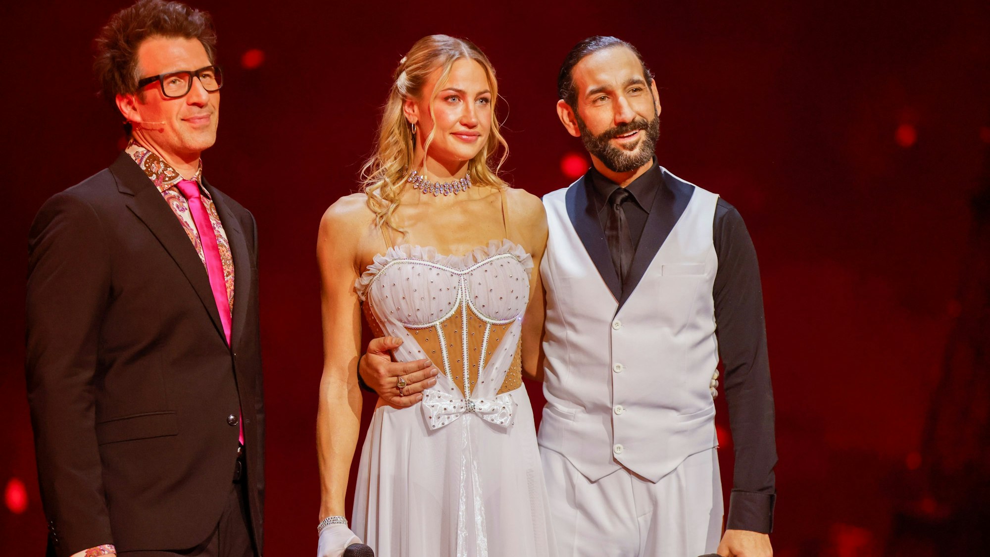 Daniel Hartwich (l-r), Moderator, Lulu, Sängerin, und Massimo Sinato, Profitänzer, stehen in der RTL-Tanzshow „Let's Dance“ in den Kulissen des Muscials „Moulin Rouge!“.