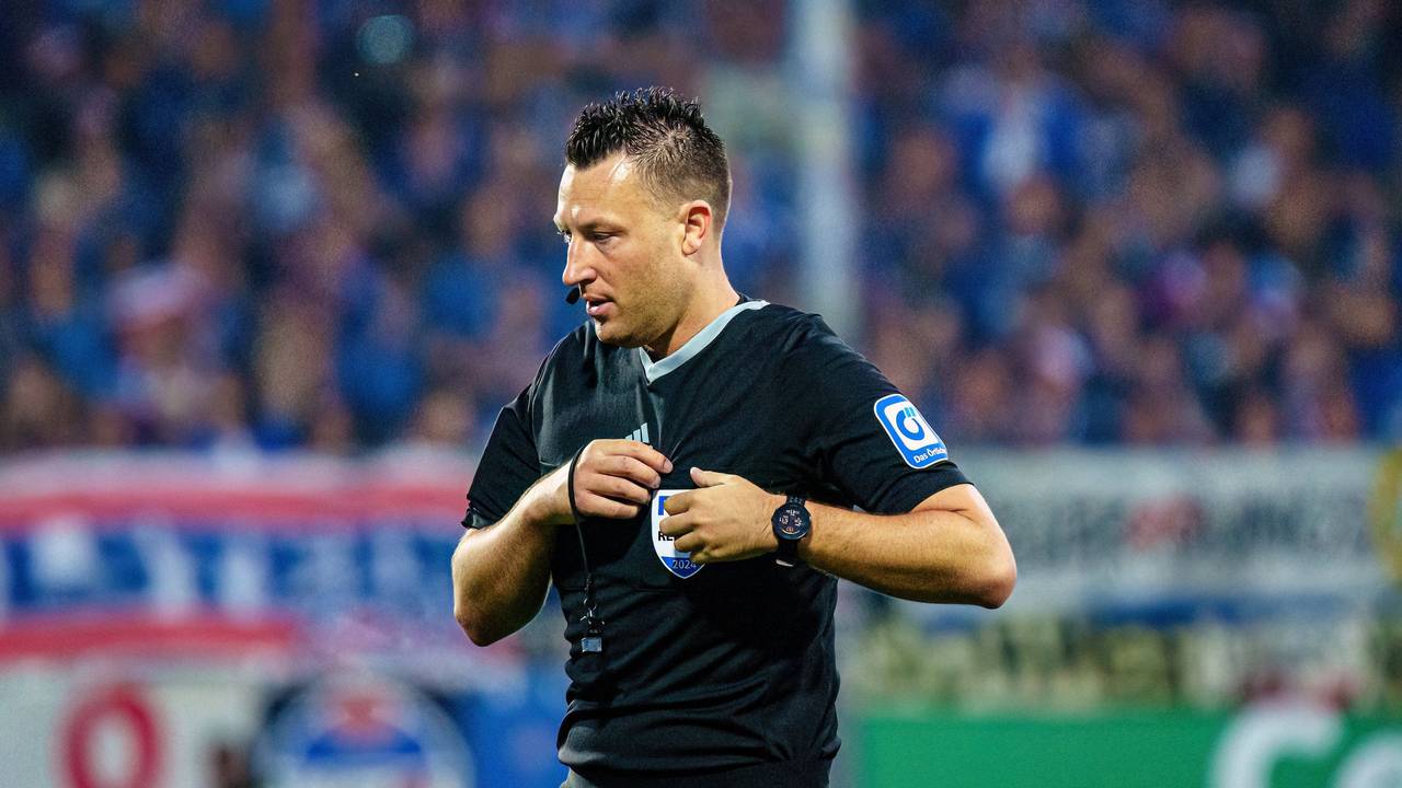 Schiedsrichter Sven Jablonski steht auf dem Platz und steckt seine Karten in die Brusttasche.