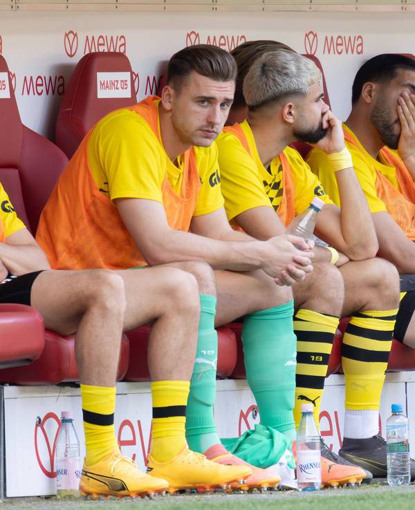 Die Ersatzspieler von Borussia Dortmund sitzen mit ernüchternden Gesichtern auf der Bank in Mainz.