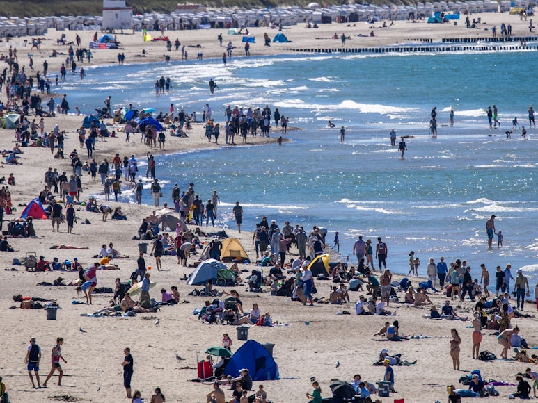 Urlauberinnen, Urlauber und Tagesgäste nutzen das sonnige, warme Wetter am 12. Mai zu einem Strandbesuch an der Ostseeküste in Warnemünde. Forschende schlagen Alarm: Unter dem Sand der Ostsee schlummert ein gefährliches Gift.dpa