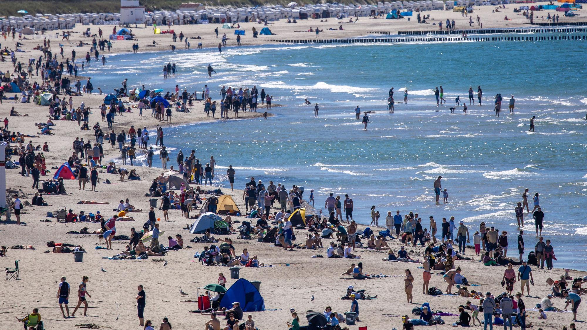 Urlauberinnen, Urlauber und Tagesgäste nutzen das sonnige, warme Wetter am 12. Mai zu einem Strandbesuch an der Ostseeküste in Warnemünde. Forschende schlagen Alarm: Unter dem Sand der Ostsee schlummert ein gefährliches Gift.dpa