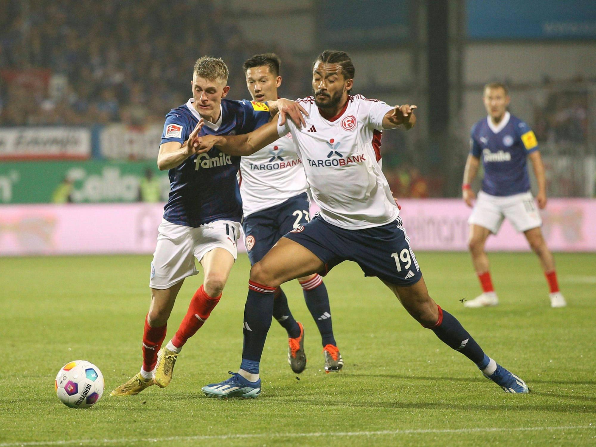 Emmanuel Iyoha grätscht gegen Alexander Bernhardsson. Im Hintergrund: Shinta Appelkamp.