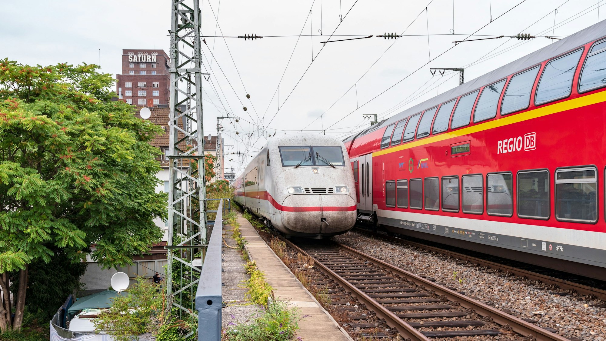 ICE fährt neben einem Regio-Zug durch Köln.