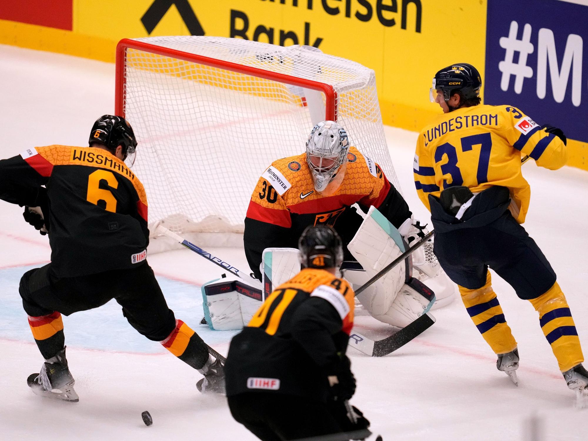 DEB-Torhüter Philipp Grubauer (M.) pariert vor dem schwedischen Spieler Isac Lundeström (r.).