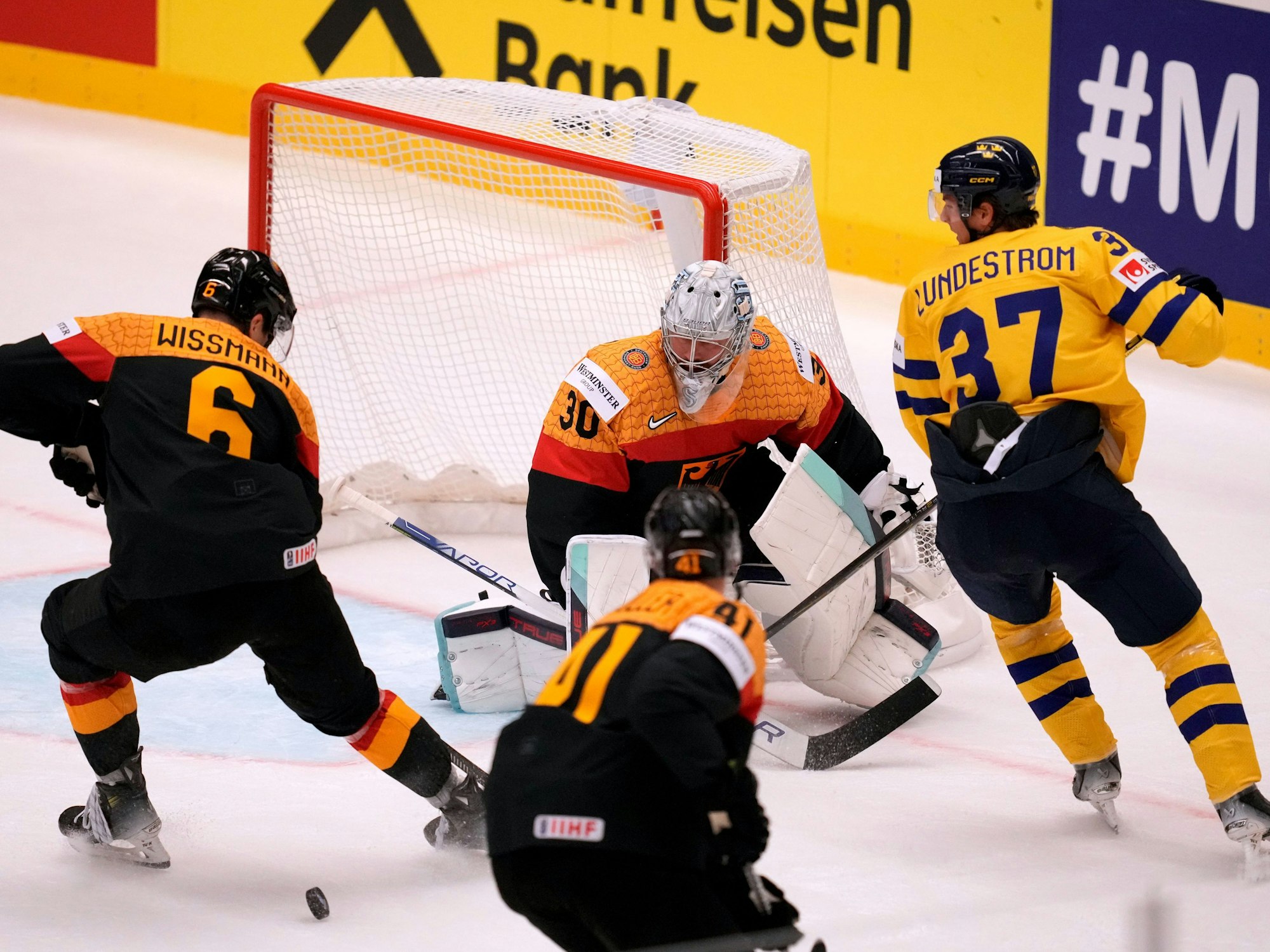 DEB-Torhüter Philipp Grubauer (M.) pariert vor dem schwedischen Spieler Isac Lundeström (r.).
