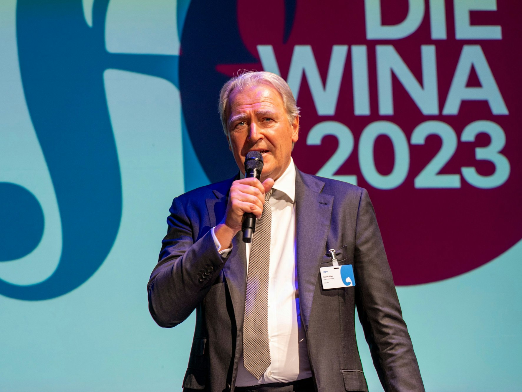 Gerald Böse steht auf einer Bühne und spricht mit Mikrofon in der Hand.