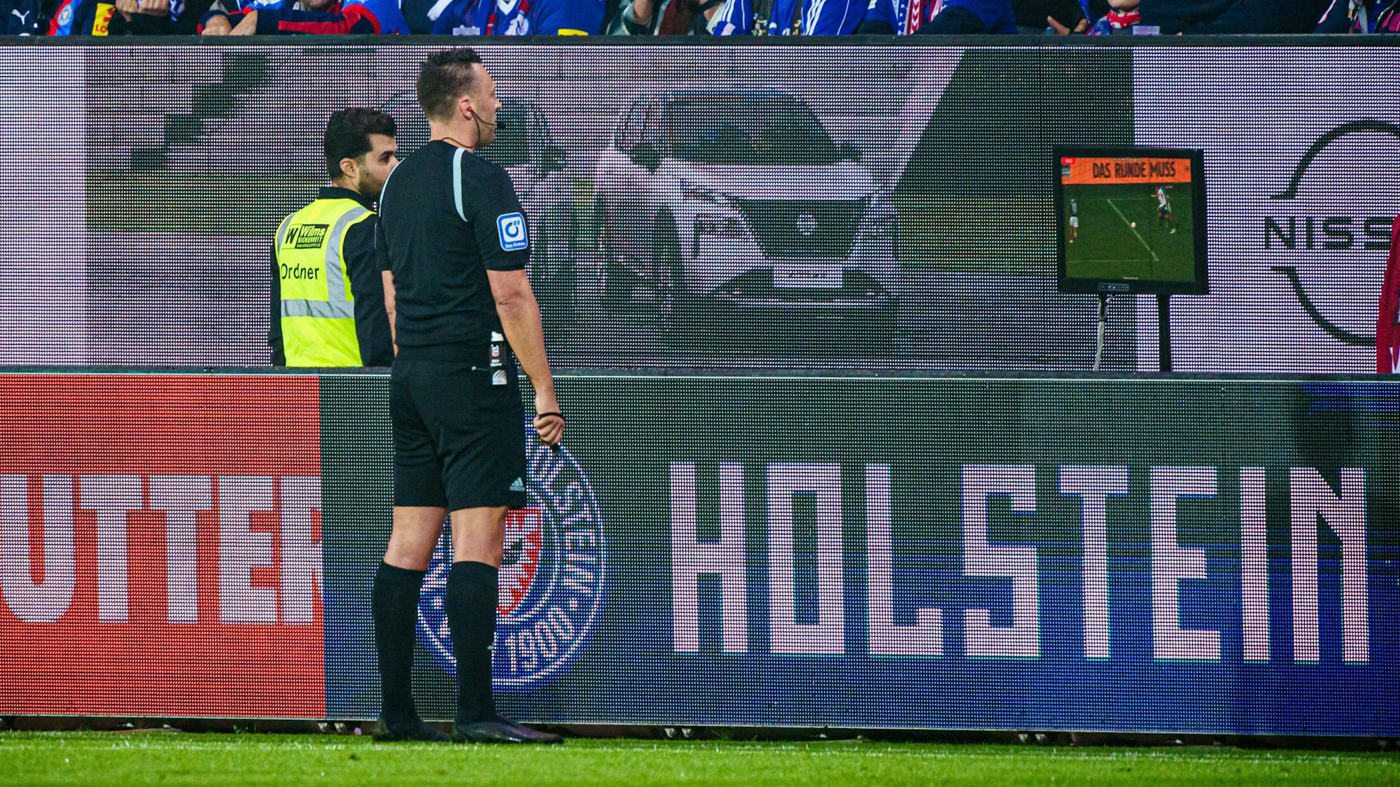 Schiedsrichter Sven Jablonski betrachtet beim Spiel Holstein Kiel gegen Fortuna Düsseldorf eine Szene am Video-Bildschirm.