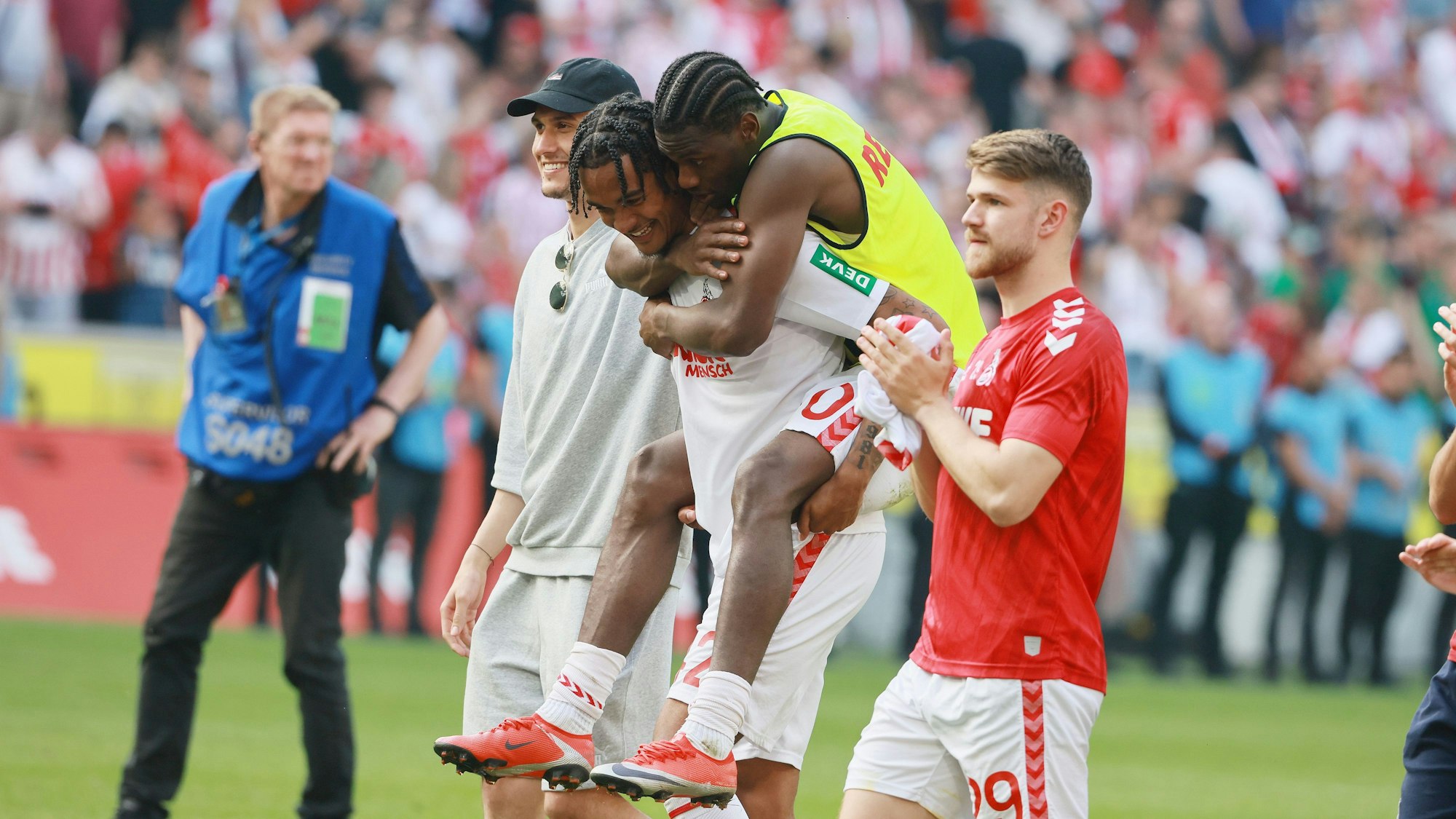 Damion Downs trägt Faride Alidou nach dem Spiel des 1. FC Heidenheim über den Rasen.