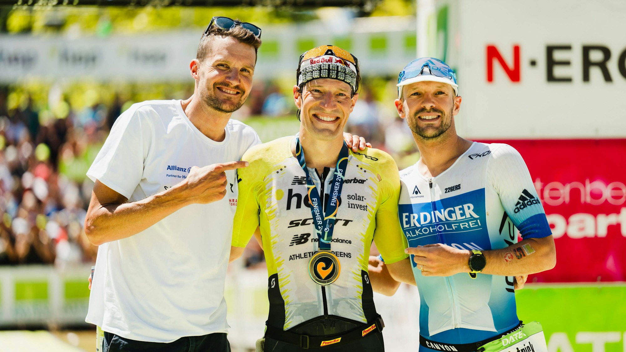 Jan Frodeno und Patrick Lange zeigen auf Sebastian Kienle.