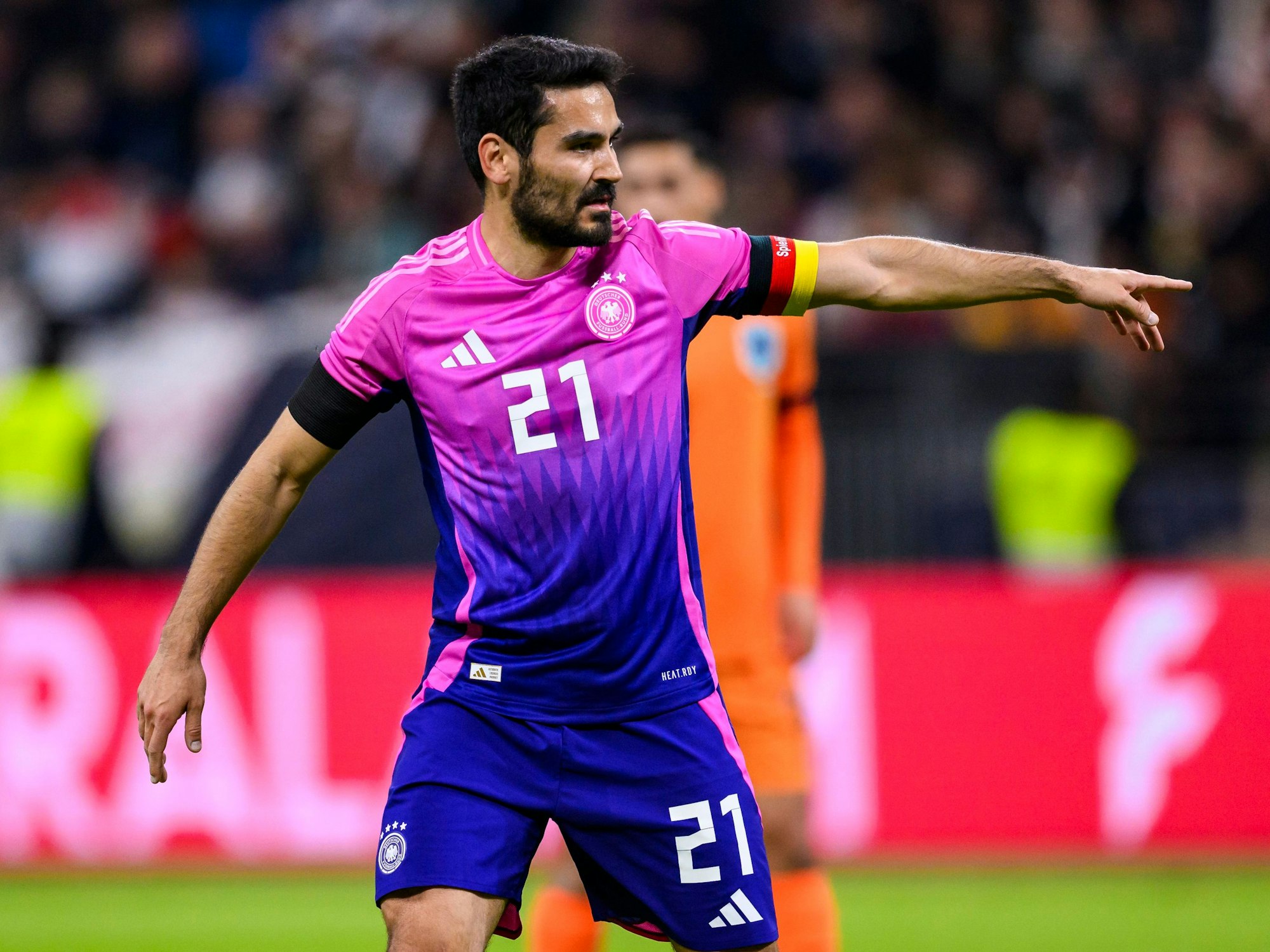 Ilkay Gündogan gibt als Kapitän der deutschen Nationalmannschaft in einem Spiel Anweisungen und zeigt mit dem Finger in eine bestimmte Richtung.