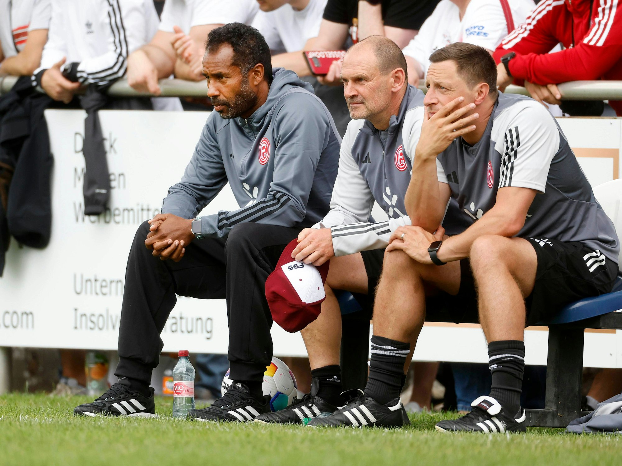 Fortuna Düsseldorfs Trainer Daniel Thioune beobachtet auf der Bank mit seinen Assistenten Manfred Stefes und Jan Hoepner sein Team im Testspiel gegen TuRu Düsseldorf.