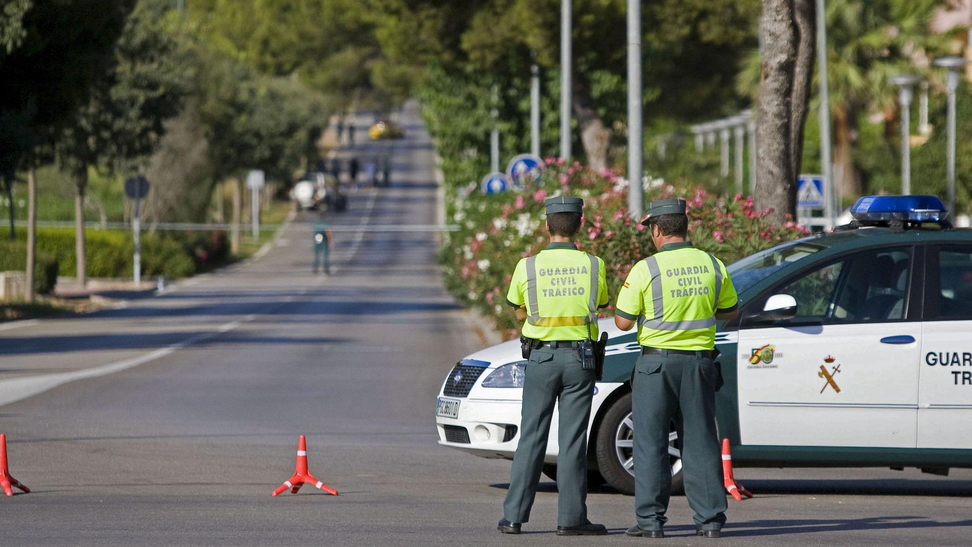 Beamte der spanischen Guardia Civil stehen auf einer Straße.