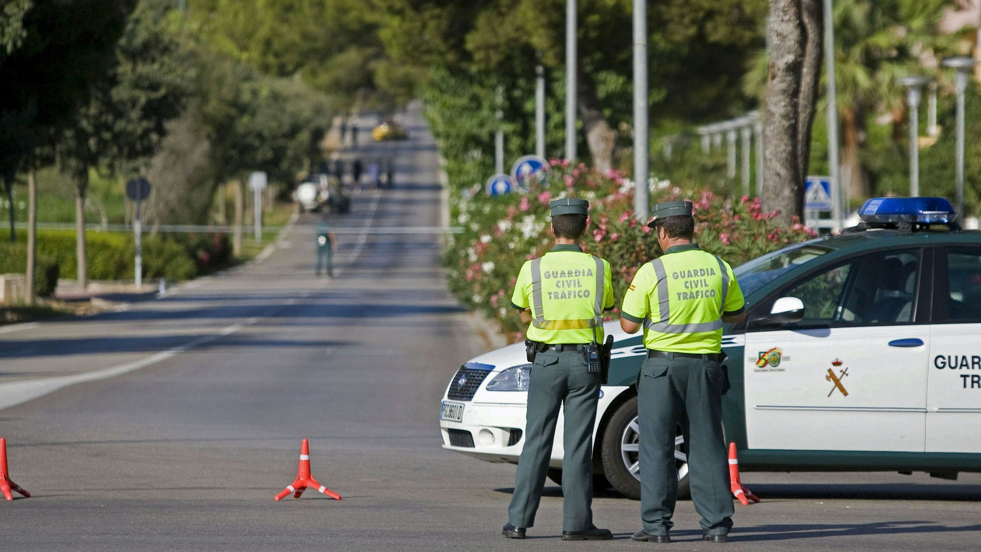 Beamte der spanischen Guardia Civil stehen auf einer Straße.