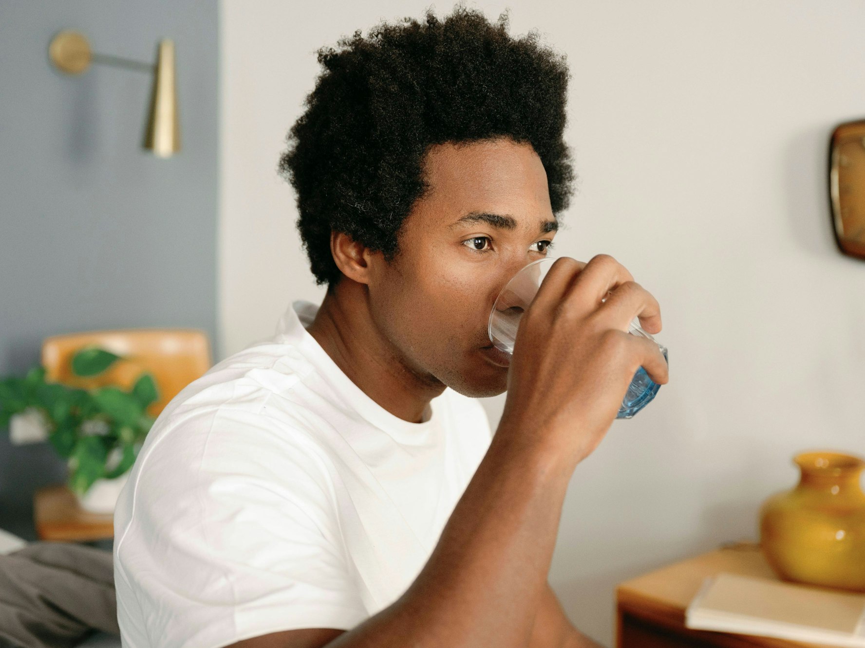 Ein Mann trinkt ein Glas Wasser.