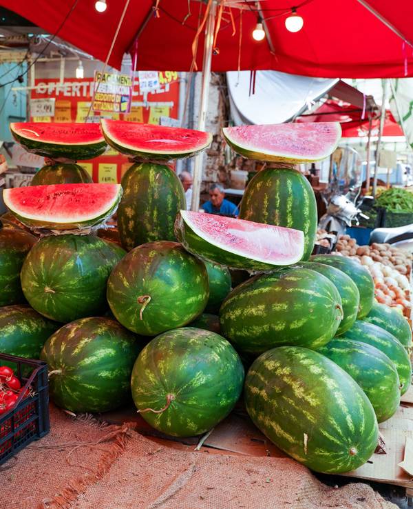 Wassermelonen liegen an einem Marktstand in Italien.