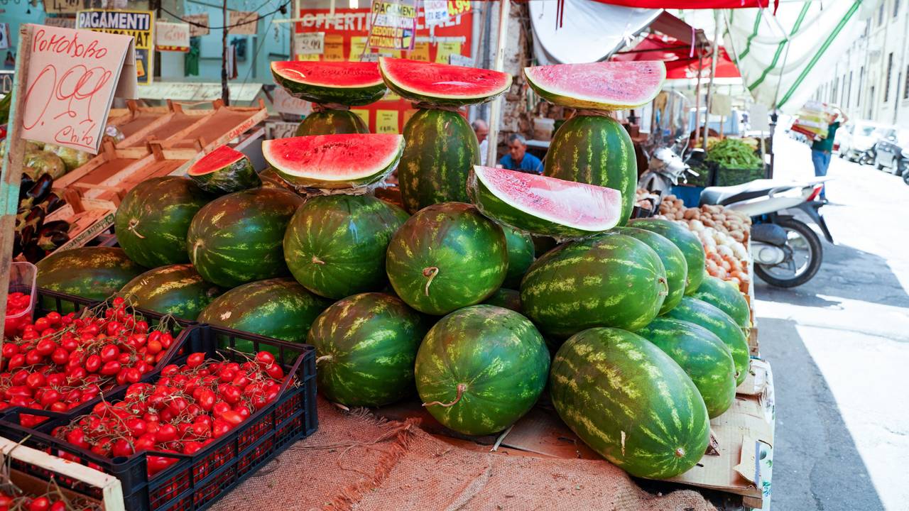 Wassermelonen liegen an einem Marktstand in Italien.